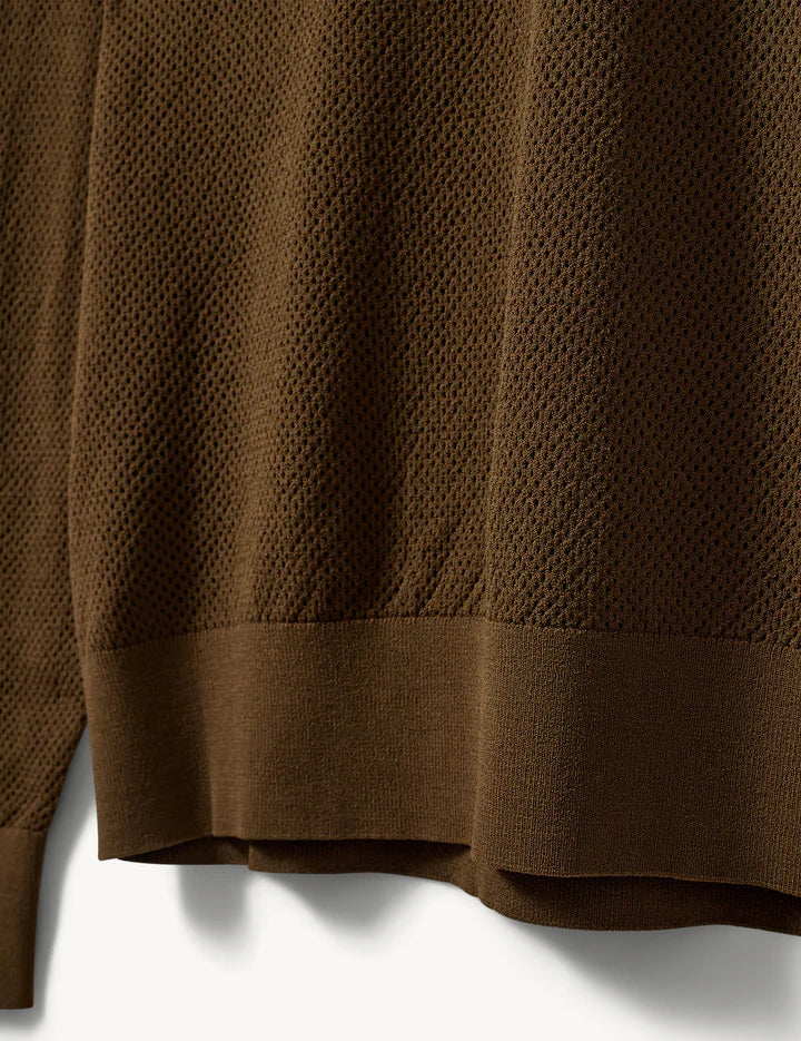Luźna bluzka polo z kołnierzykiem Madison The Garment. Przy dekolcie zapinana na guziki. Bluzka ma luźny fason i prosty krój. Wykonana z cienkiej dzianiny z drobnym, ażurowym wzorem