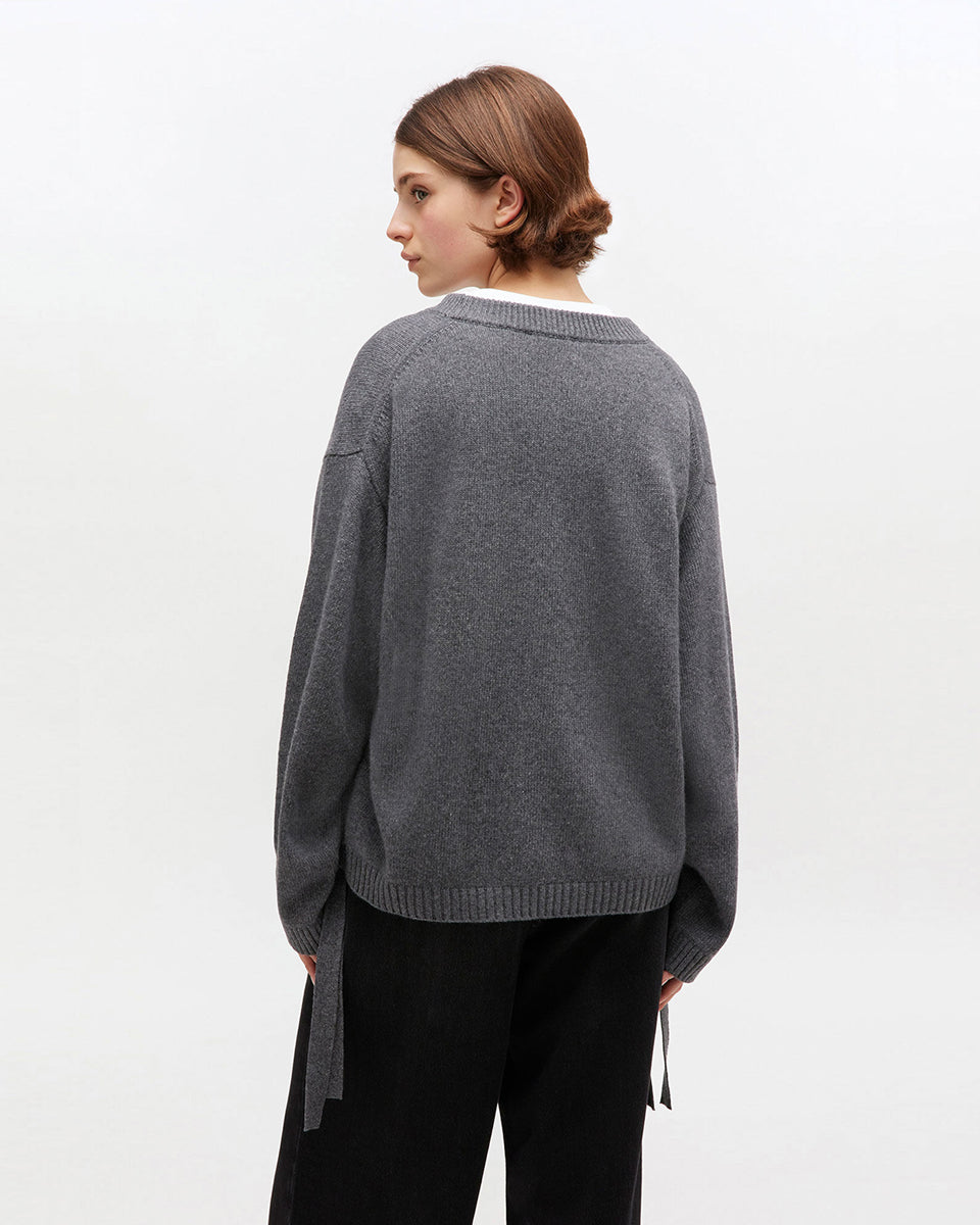 Szary, oversizowy sweter 2632 Charcoal Grey marki GANNI z okrągłym dekoltem i długimi rękawami. Posiada niewielkie logo marki na lewej piersi. Zakończony ściągaczami i wiązaniami u dołu. Wykonany z dzianiny z wełną. 