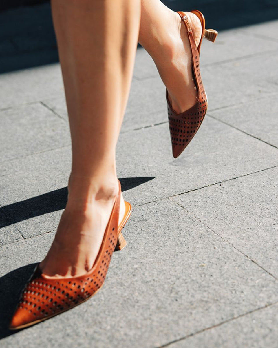 Ręcznie wykonane czółenka typu sling back 9459 Brown Billi Bi Copenhagen z brązowej, gładkiej skóry. Mają noski w szpic, co optycznie wydłuża stopę. Charakterystycznym elementem jest ażurowa tekstura. Buty mają niski, stabilny obcas z fakturą przypominającą jasne drewno. Idealnie sprawdzą się na codzień.
-Buty mają standardową rozmiarówkę. Zamów je w rozmiarze jaki normalnie nosisz