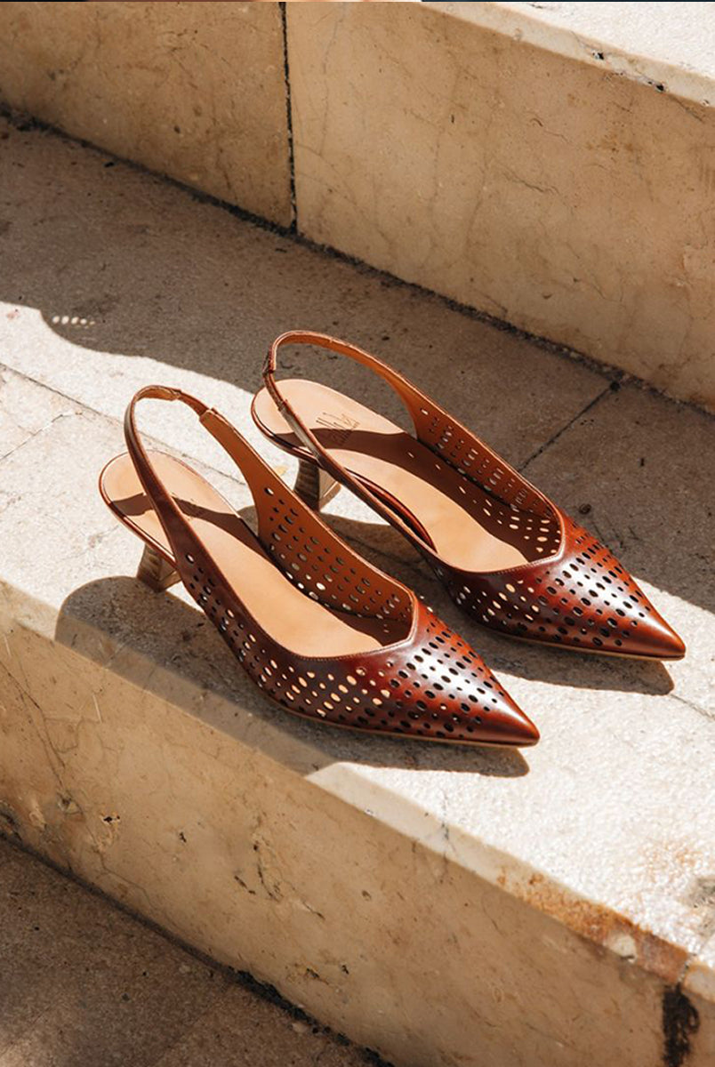 Ręcznie wykonane czółenka typu sling back 9459 Brown Billi Bi Copenhagen z brązowej, gładkiej skóry. Mają noski w szpic, co optycznie wydłuża stopę. Charakterystycznym elementem jest ażurowa tekstura. Buty mają niski, stabilny obcas z fakturą przypominającą jasne drewno. Idealnie sprawdzą się na codzień.
-Buty mają standardową rozmiarówkę. Zamów je w rozmiarze jaki normalnie nosisz