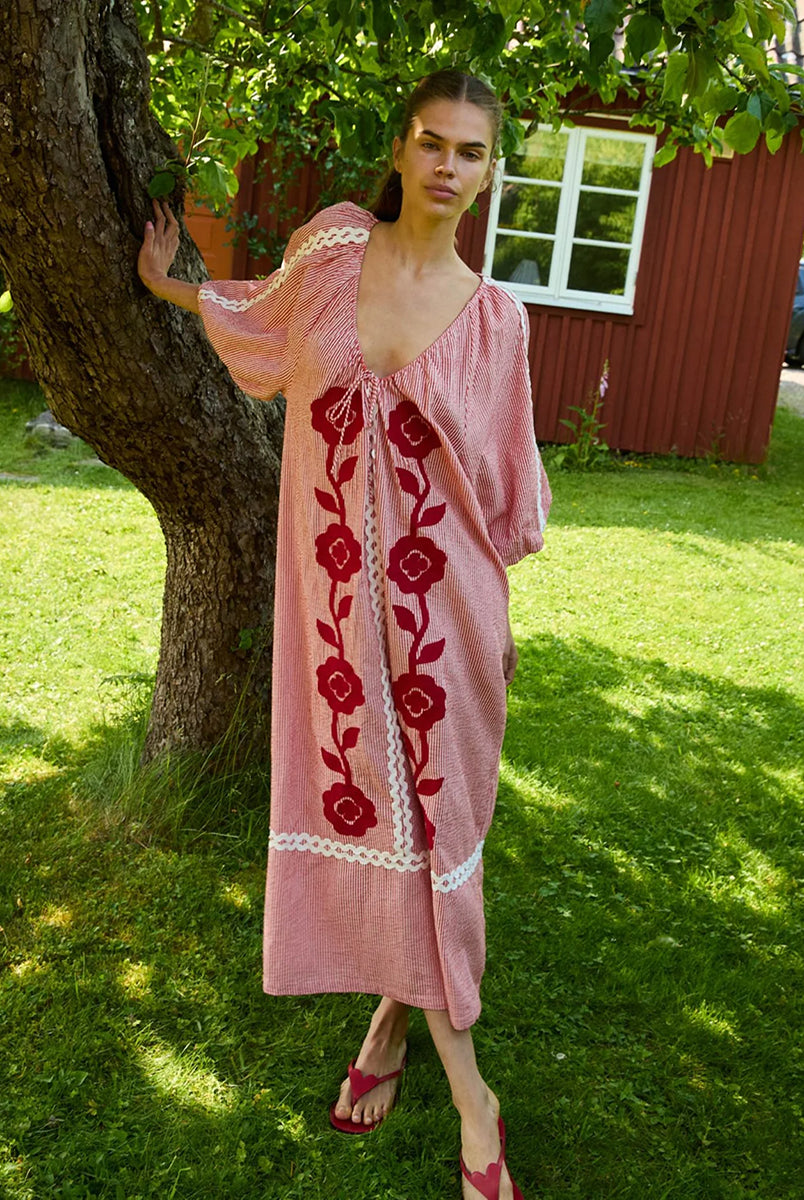 Szeroka, luźna sukienka Abelone Red Flower marki SISSEL EDELBO z obszernymi rękawami typu raglan z elastycznymi otworami i szerokim dekoltem w serek, który ściągany jest regulowanym sznurkiem. Posiada miękką podszewkę, która nadaje bufiasty kształt. Ozdobiona jest wyrazistym, kwiatowym haftem oraz szerokimi, zygzakowatymi taśmami. Wykonana w 100% z jakościowej bawełny organicznej.
-Luźny, szeroki krój
-Kwiatowy haft
-Ściągany dekolt w serek
-ONE SIZE