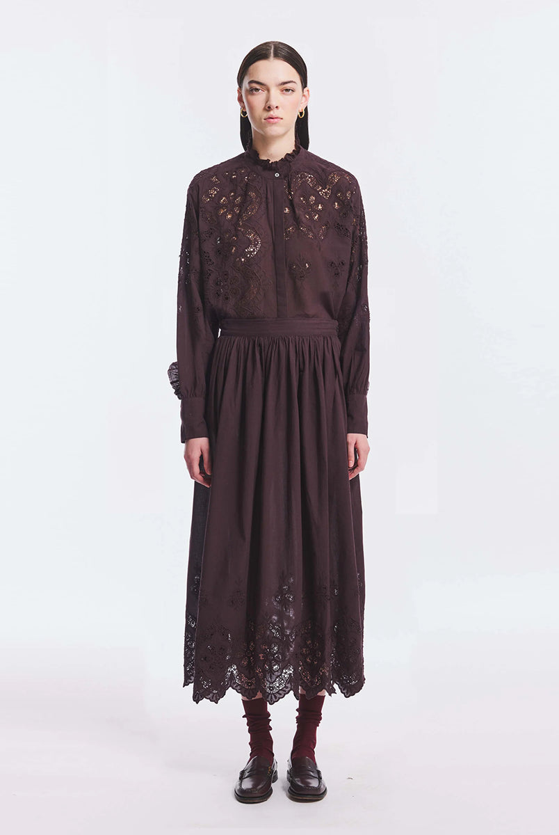 Haftowana, bawełniana bluzka Albertine Antik Batik Burgundy z długimi rękawami i niewielką stójką, która wykończona jest falbanką. Posiada ażurowy haft z przodu i na rękawach. Ma kryte zapięcie na guziki. Ta zwiewna bluzka, inspirowana modą wiktoriańską może być noszona samodzielnie lub w komplecie z pasującą spódnicą, tworząc romantyczną stylizację. 