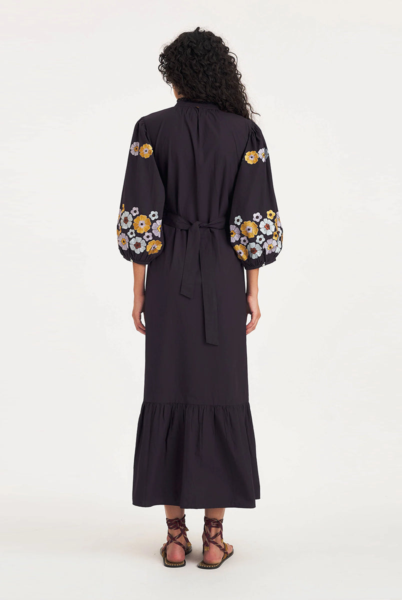 Długa sukienka Amantina Maxi Navy marki Antik Batik z bufiastymi rękawami do łokci i okrągłym dekoltem zapinanym na guziczki. Zdobiona jedwabnym haftem kwiatowym na biuście i wokół rękawów. Plisa i kołnierzyk ozdobione są koronką, a całość uzupełnia bawełniany pasek podkreślający talię i falbana u dołu. Długość sięga do połowy łydki. Wykonana z bawełnianej popeliny.
-Bufiaste rękawy
-Kwiatowy haft i koronka
-Zamów w swoim standardowym rozmiarze