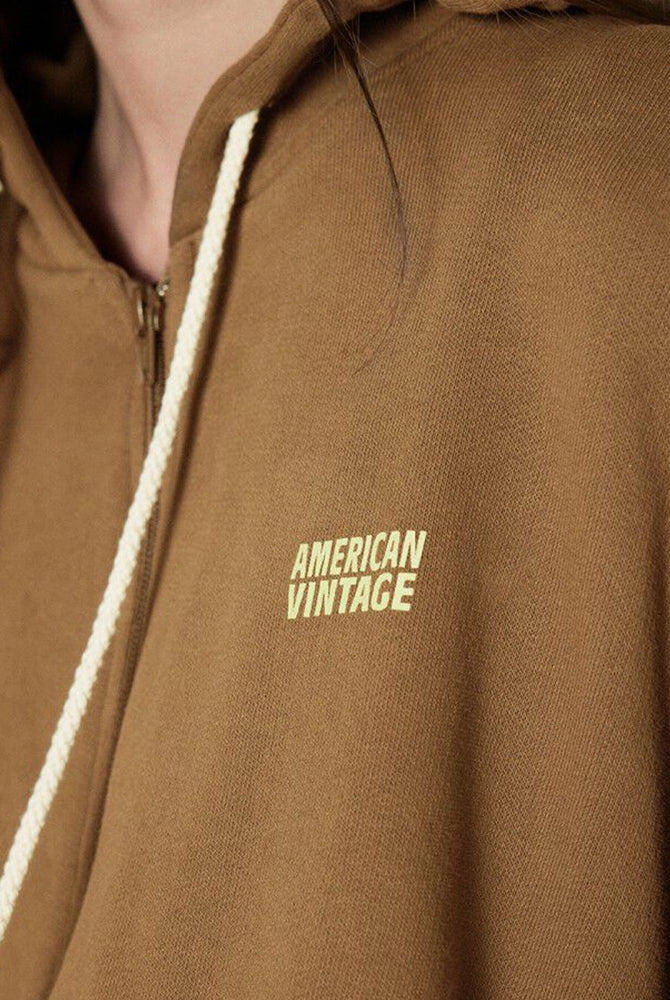 Oversizowa bluza dresowa z kapturem IZUBIRD American Vintage. Zapinana na zamek błyskawiczny. Nad lewą piersią posiada neonowe, niewielkie logo marki. Wykończona ściągaczami.