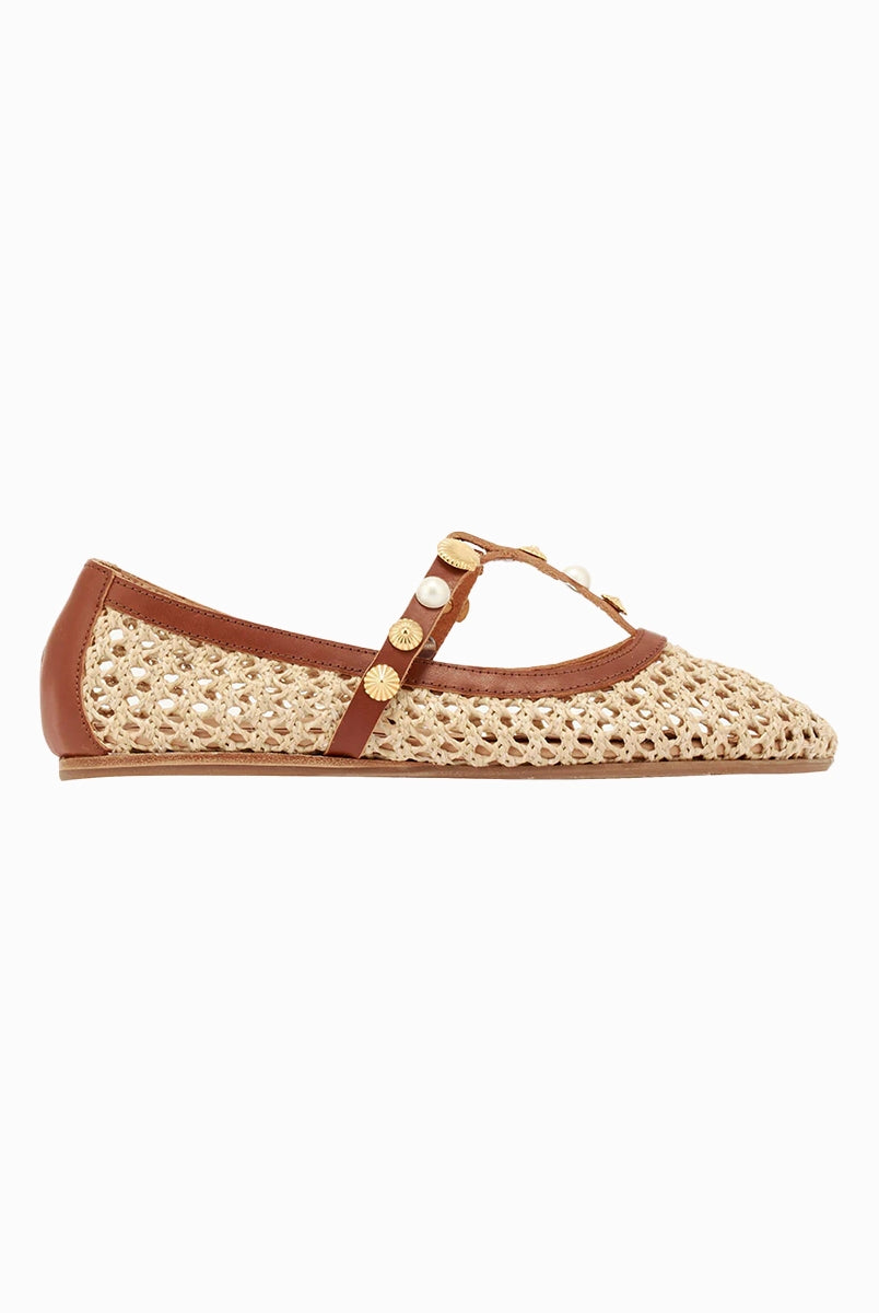 Plecione, ażurowe baletki na płaskiej podeszwie Aerati Ancient Greek Sandals z cienkimi, skórzanymi, skrzyżowanymi paskami dekorowanymi biżuteryjnymi aplikacjami z motywami muszelek i sztucznych pereł. Wykonane z rafii i miękkiej skóry naturalnej.