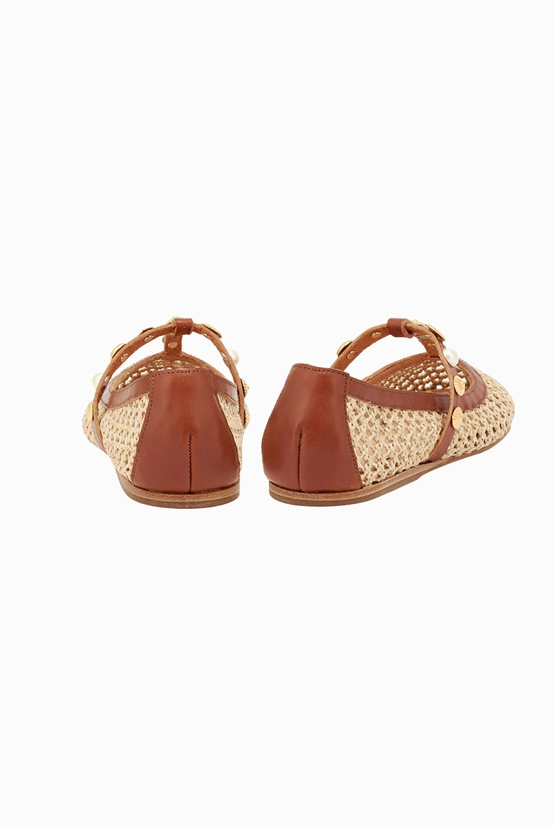 Plecione, ażurowe baletki na płaskiej podeszwie Aerati Ancient Greek Sandals z cienkimi, skórzanymi, skrzyżowanymi paskami dekorowanymi biżuteryjnymi aplikacjami z motywami muszelek i sztucznych pereł. Wykonane z rafii i miękkiej skóry naturalnej.