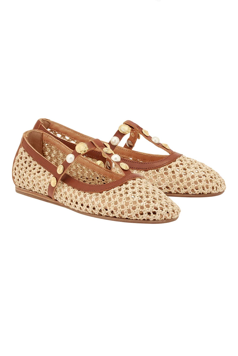 Plecione, ażurowe baletki na płaskiej podeszwie Aerati Ancient Greek Sandals z cienkimi, skórzanymi, skrzyżowanymi paskami dekorowanymi biżuteryjnymi aplikacjami z motywami muszelek i sztucznych pereł. Wykonane z rafii i miękkiej skóry naturalnej.