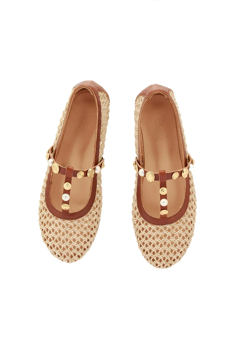 Plecione, ażurowe baletki na płaskiej podeszwie Aerati Ancient Greek Sandals z cienkimi, skórzanymi, skrzyżowanymi paskami dekorowanymi biżuteryjnymi aplikacjami z motywami muszelek i sztucznych pereł. Wykonane z rafii i miękkiej skóry naturalnej.