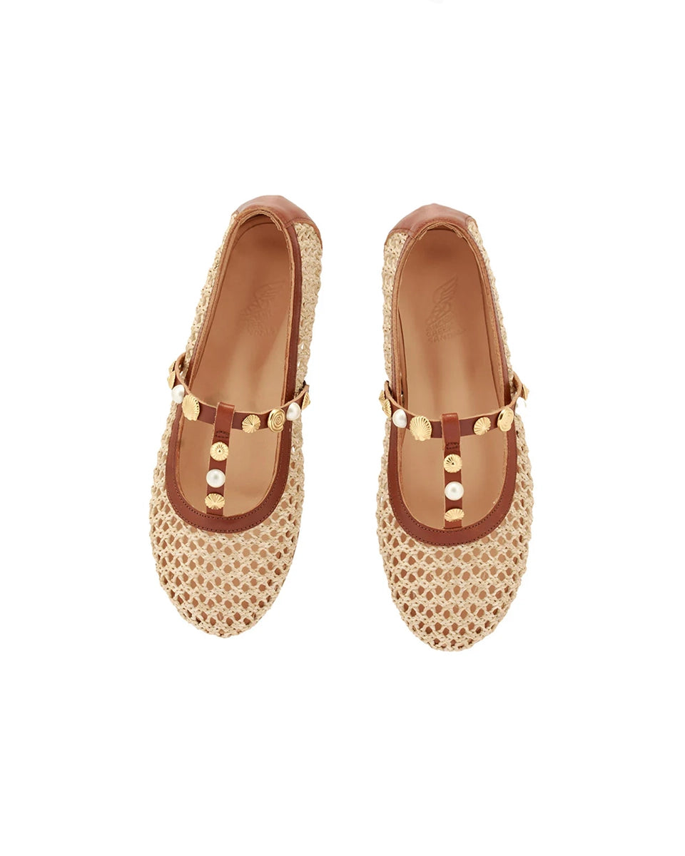 Plecione, ażurowe baletki na płaskiej podeszwie Aerati Ancient Greek Sandals z cienkimi, skórzanymi, skrzyżowanymi paskami dekorowanymi biżuteryjnymi aplikacjami z motywami muszelek i sztucznych pereł. Wykonane z rafii i miękkiej skóry naturalnej.