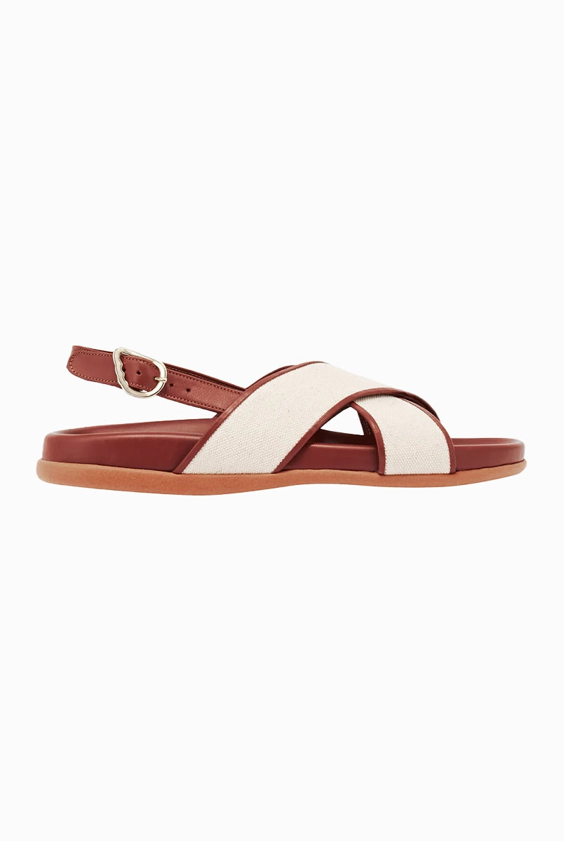 Skórzane sandały Ikesia Ancient Greek Sandals na płaskiej, profilowanej od wewnętrznej strony podeszwie z szerokimi, skrzyżowanymi paskami na górze obszytymi naturalną, płócienną tkaniną.