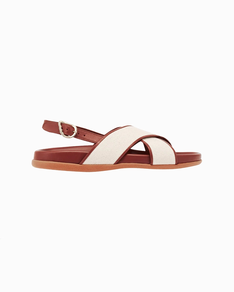 Skórzane sandały Ikesia Ancient Greek Sandals na płaskiej, profilowanej od wewnętrznej strony podeszwie z szerokimi, skrzyżowanymi paskami na górze obszytymi naturalną, płócienną tkaniną.