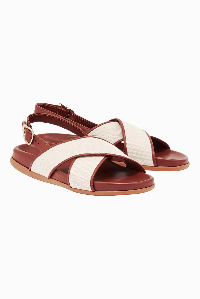 Skórzane sandały Ikesia Ancient Greek Sandals na płaskiej, profilowanej od wewnętrznej strony podeszwie z szerokimi, skrzyżowanymi paskami na górze obszytymi naturalną, płócienną tkaniną.