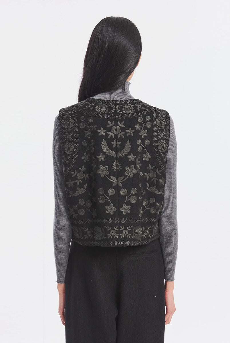 Krótka kamizelka Bertille Black marki Antik Batik o wyraźnym, etnicznym charakterze nawiązującym do stylu boho-chic. Jest to fason sięgający do linii bioder, z otwartym przodem. Zapinana przy szyi za pomocą jednego guzika. Wykonana z miękkiej tkaniny z wełną. Kamizelka ma podszewkę.