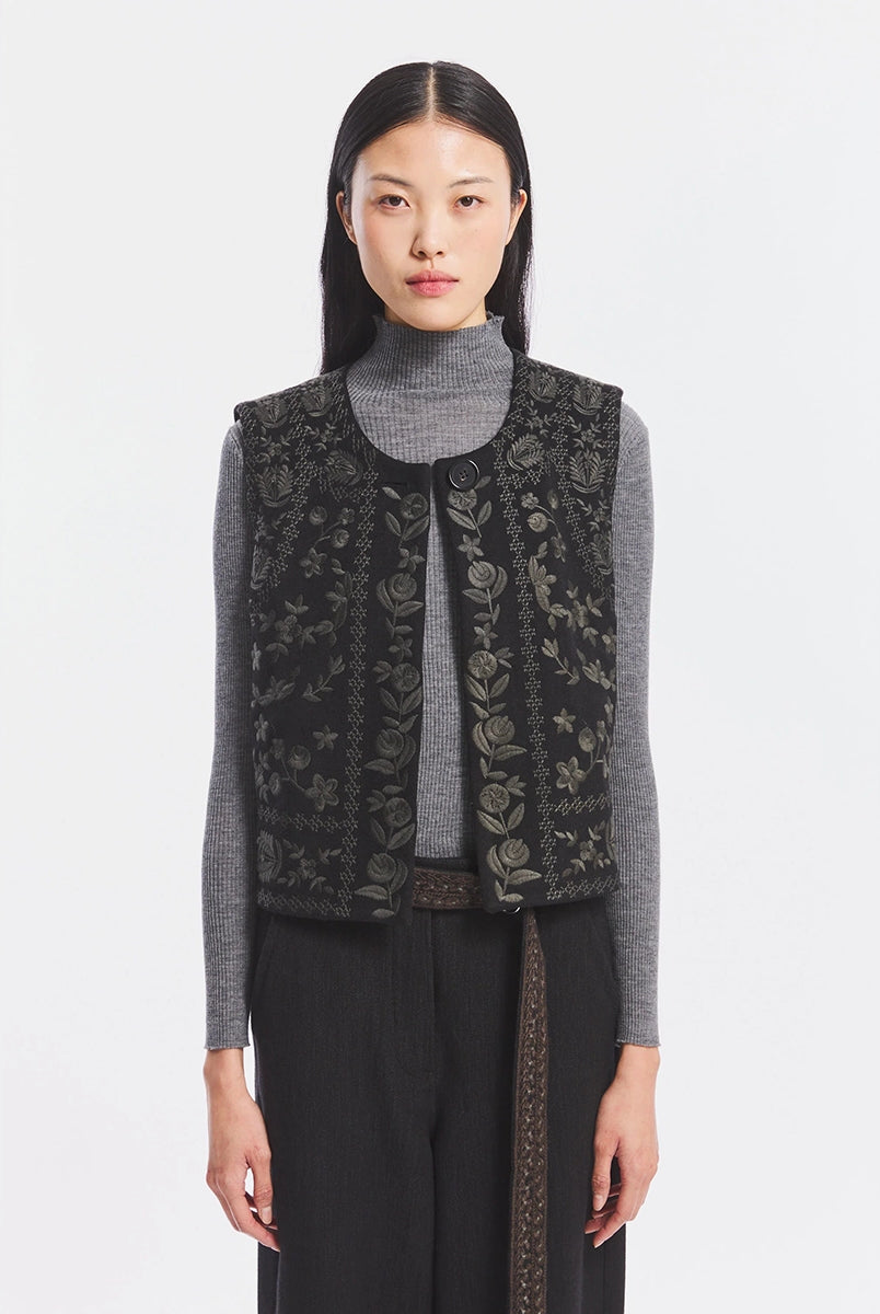Krótka kamizelka Bertille Black marki Antik Batik o wyraźnym, etnicznym charakterze nawiązującym do stylu boho-chic. Jest to fason sięgający do linii bioder, z otwartym przodem. Zapinana przy szyi za pomocą jednego guzika. Wykonana z miękkiej tkaniny z wełną. Kamizelka ma podszewkę.