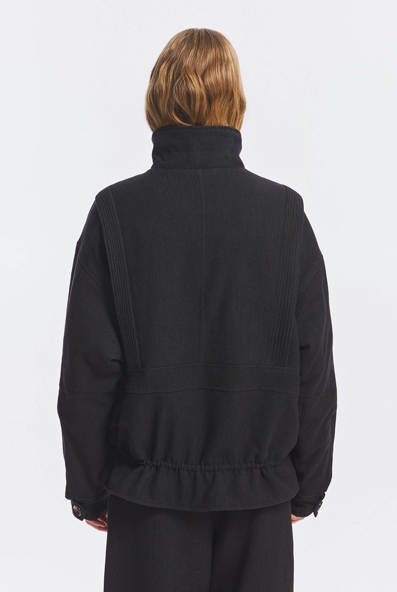 Kurtka o kroju oversize Aristide Antik Batik Grey z wysokim kołnierzem i zapięciem na guziki. Wykonana z mieszanki bawełny, wełny i nylonu. Model ten wyróżnia się strukturalną formą i swobodnym ułożeniem na sylwetce. Przód zdobią delikatne, kwiatowe hafty, które nadają kurtce fakturę i charakter. Posiada dwie naszywane kieszenie i dwie kieszenie boczne. Regulowany u dołu sznurek pozwala na dowolne podkreślenie sylwetki. Model wykończony podszewką z lyocellu. 