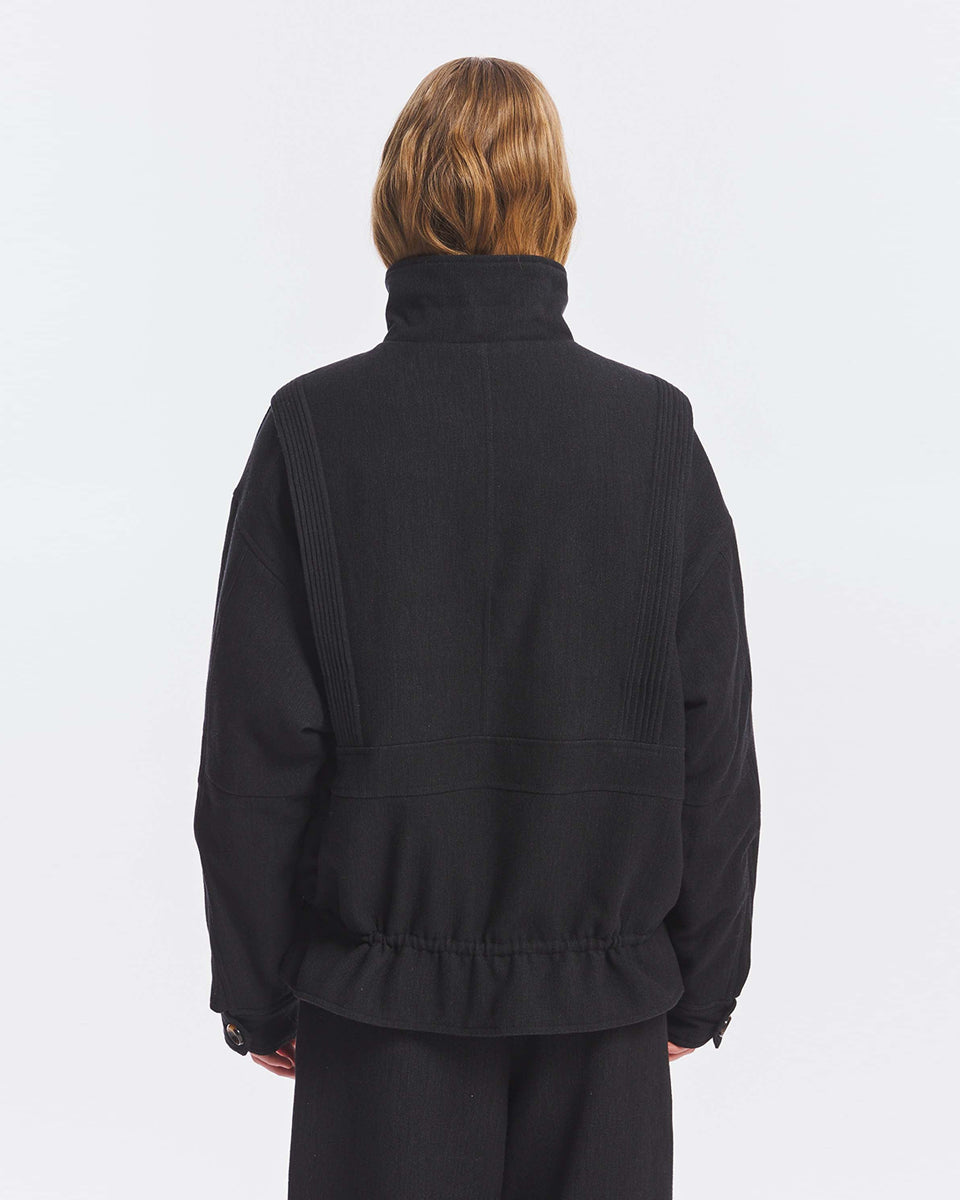 Kurtka o kroju oversize Aristide Antik Batik Grey z wysokim kołnierzem i zapięciem na guziki. Wykonana z mieszanki bawełny, wełny i nylonu. Model ten wyróżnia się strukturalną formą i swobodnym ułożeniem na sylwetce. Przód zdobią delikatne, kwiatowe hafty, które nadają kurtce fakturę i charakter. Posiada dwie naszywane kieszenie i dwie kieszenie boczne. Regulowany u dołu sznurek pozwala na dowolne podkreślenie sylwetki. Model wykończony podszewką z lyocellu. 