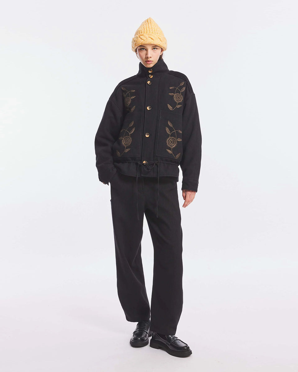 Kurtka o kroju oversize Aristide Antik Batik Grey z wysokim kołnierzem i zapięciem na guziki. Wykonana z mieszanki bawełny, wełny i nylonu. Model ten wyróżnia się strukturalną formą i swobodnym ułożeniem na sylwetce. Przód zdobią delikatne, kwiatowe hafty, które nadają kurtce fakturę i charakter. Posiada dwie naszywane kieszenie i dwie kieszenie boczne. Regulowany u dołu sznurek pozwala na dowolne podkreślenie sylwetki. Model wykończony podszewką z lyocellu. 
