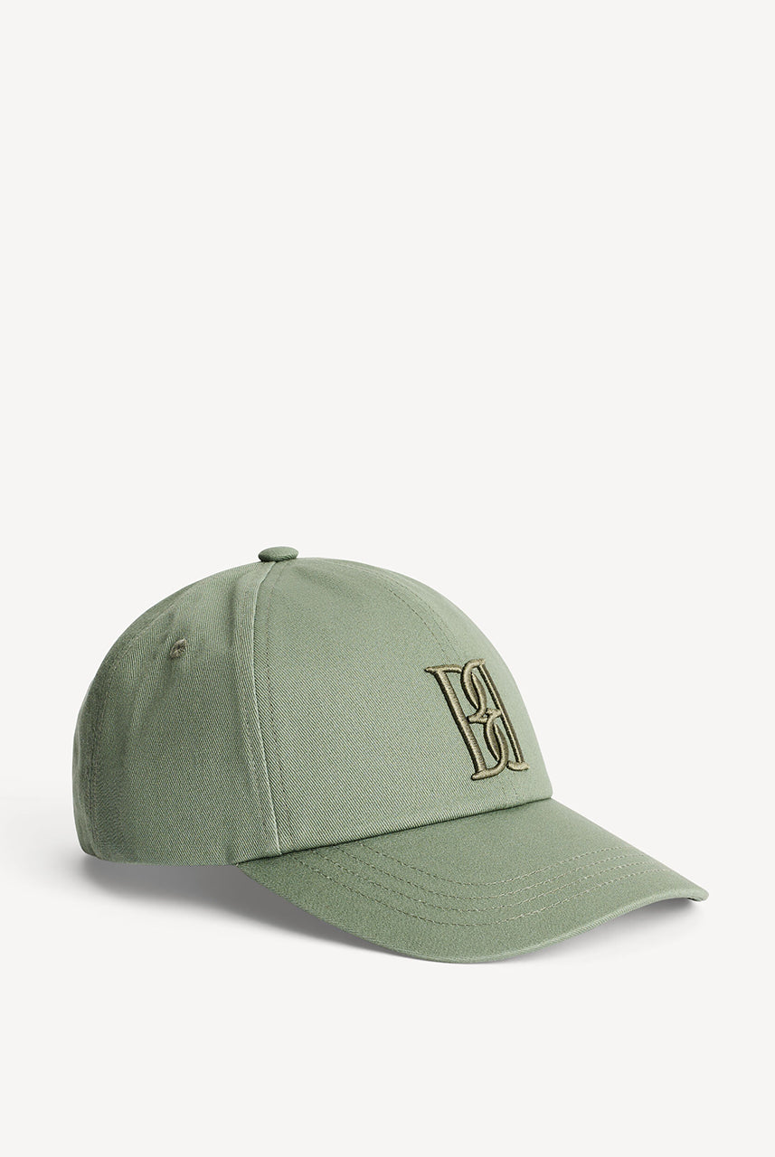 Stylowa, praktyczna czapka z daszkiem Aubrieli Deep Lichen Green By Malene Birger. Doda głębi sezonowym stylizacjom i ochroni przed słońcem. Z tyłu znajduje się wygodny, regulowany pasek z zakładką, a z przodu duży, haftowany monogram. 