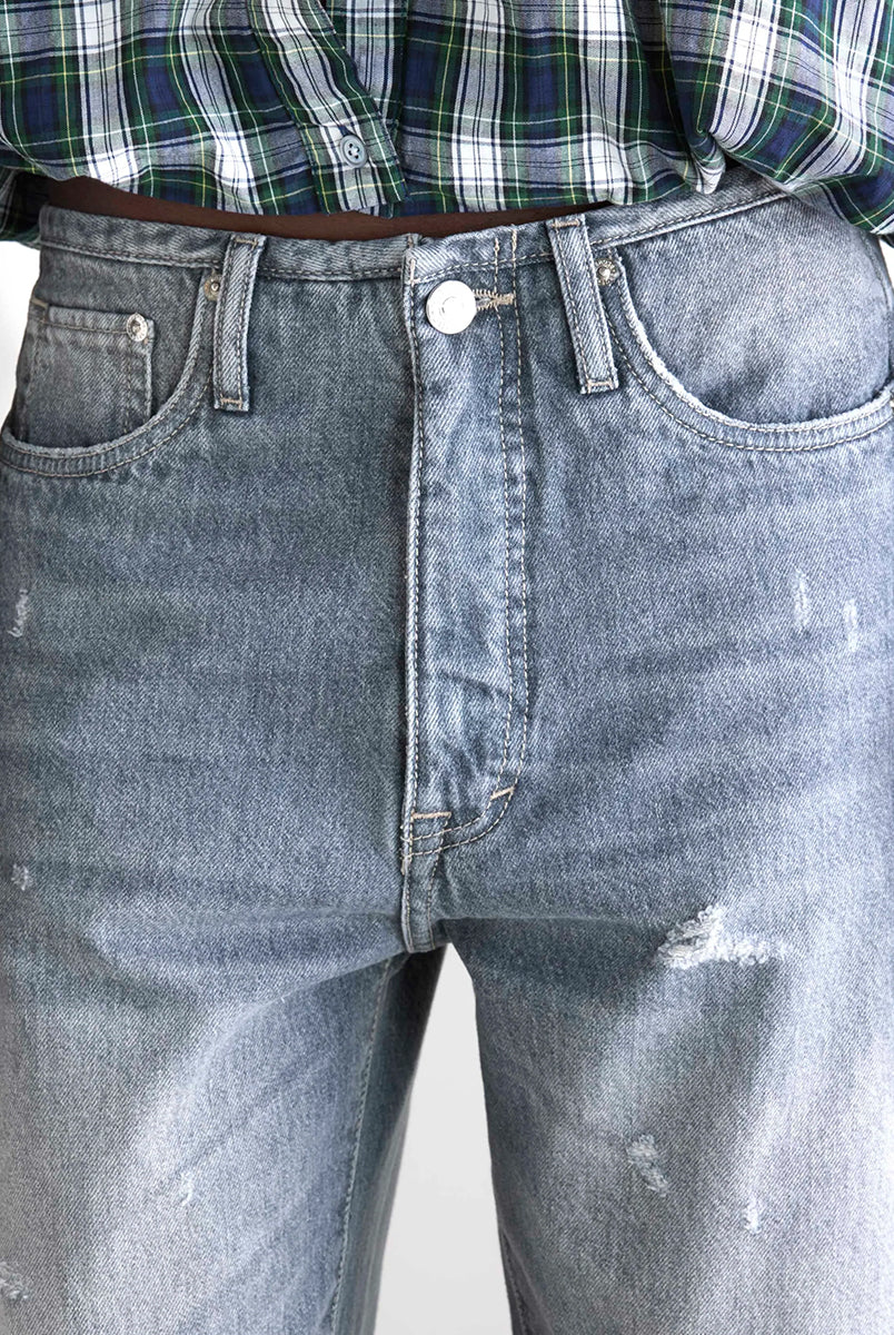 Luźne, szare jeansy z niskim stanem Pacy Bellerose z zaokrągloną nogawką i dwoma szwami po bokach. Wykonane z bawełnianego denimu z przetarciami. Spodnie mają pięć kieszeni. Zapinane na guzik i zamek błyskawiczny.
