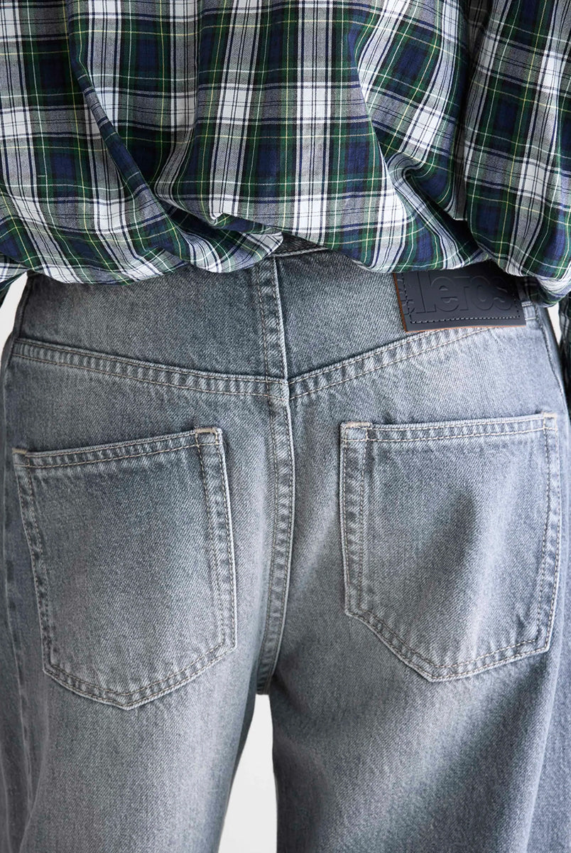 Luźne, szare jeansy z niskim stanem Pacy Bellerose z zaokrągloną nogawką i dwoma szwami po bokach. Wykonane z bawełnianego denimu z przetarciami. Spodnie mają pięć kieszeni. Zapinane na guzik i zamek błyskawiczny.