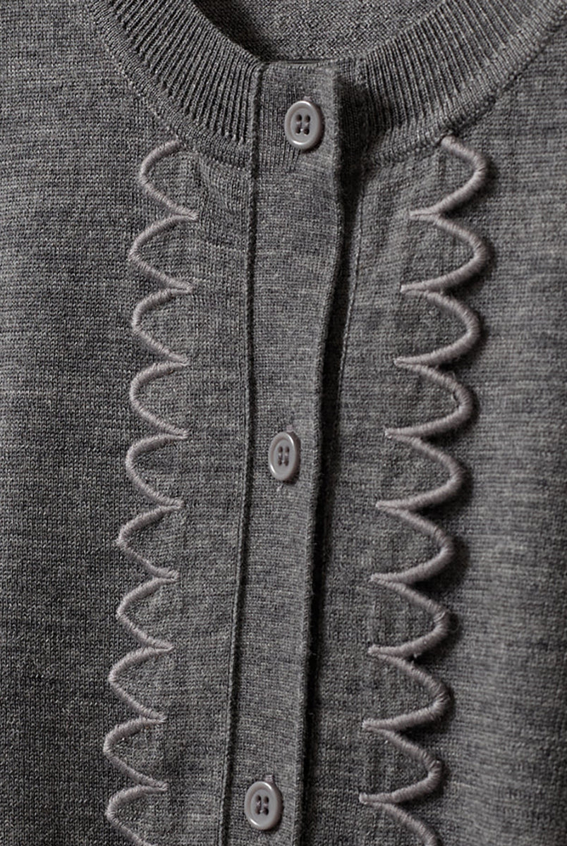 Dzianinowy, swobodny kardigan Bergen Scallop Grey Melange o prostym kroju i długich rękawach. Wyróżnia się subtelnym, ażurowym detalem na przodzie, inspirowanym koronką, który nadaje całości ciekawą fakturę. Jest lekki, a zarazem przytulny- idealnie sprawdza się w warstwowych stylizacjach, tworząc delikatny i wyrafinowany zestaw na co dzień. Wykonany z wełny merino.
-Swobodny, prosty krój
-100% wełna merino