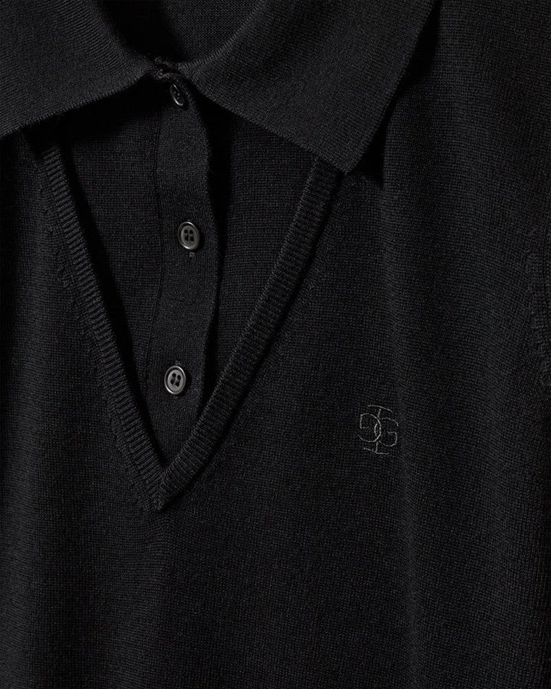 Cienki, wełniany sweter polo Bergen The Garment z kołnierzykiem imitacją dekoltu w serek. Wykonany z miękkiej dzianiny z wełny merynosa. Sweter ma luźny krój i wykończony jest ściągaczami.