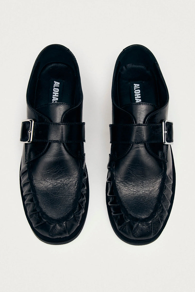 Czarne mokasyny Alohas Brandy Black Leather Loafers ze srebrną klamrą, która dodaje elegancji. Model charakteryzuje się unikatowym, marszczonym wykończeniem na nosku. Wykonane z wysokiej jakości skóry. Idealnie łączą ponadczasowy design z nowoczesnymi detalami.