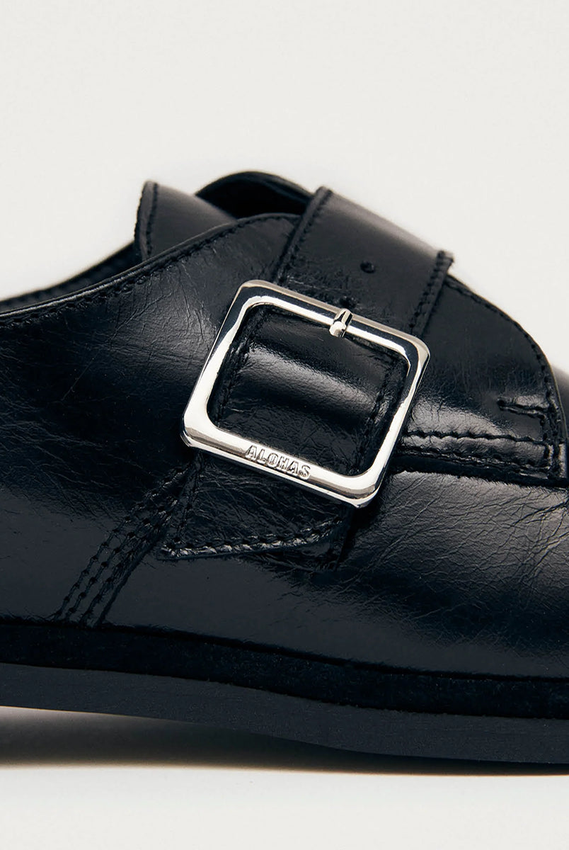 Czarne mokasyny Alohas Brandy Black Leather Loafers ze srebrną klamrą, która dodaje elegancji. Model charakteryzuje się unikatowym, marszczonym wykończeniem na nosku. Wykonane z wysokiej jakości skóry. Idealnie łączą ponadczasowy design z nowoczesnymi detalami.