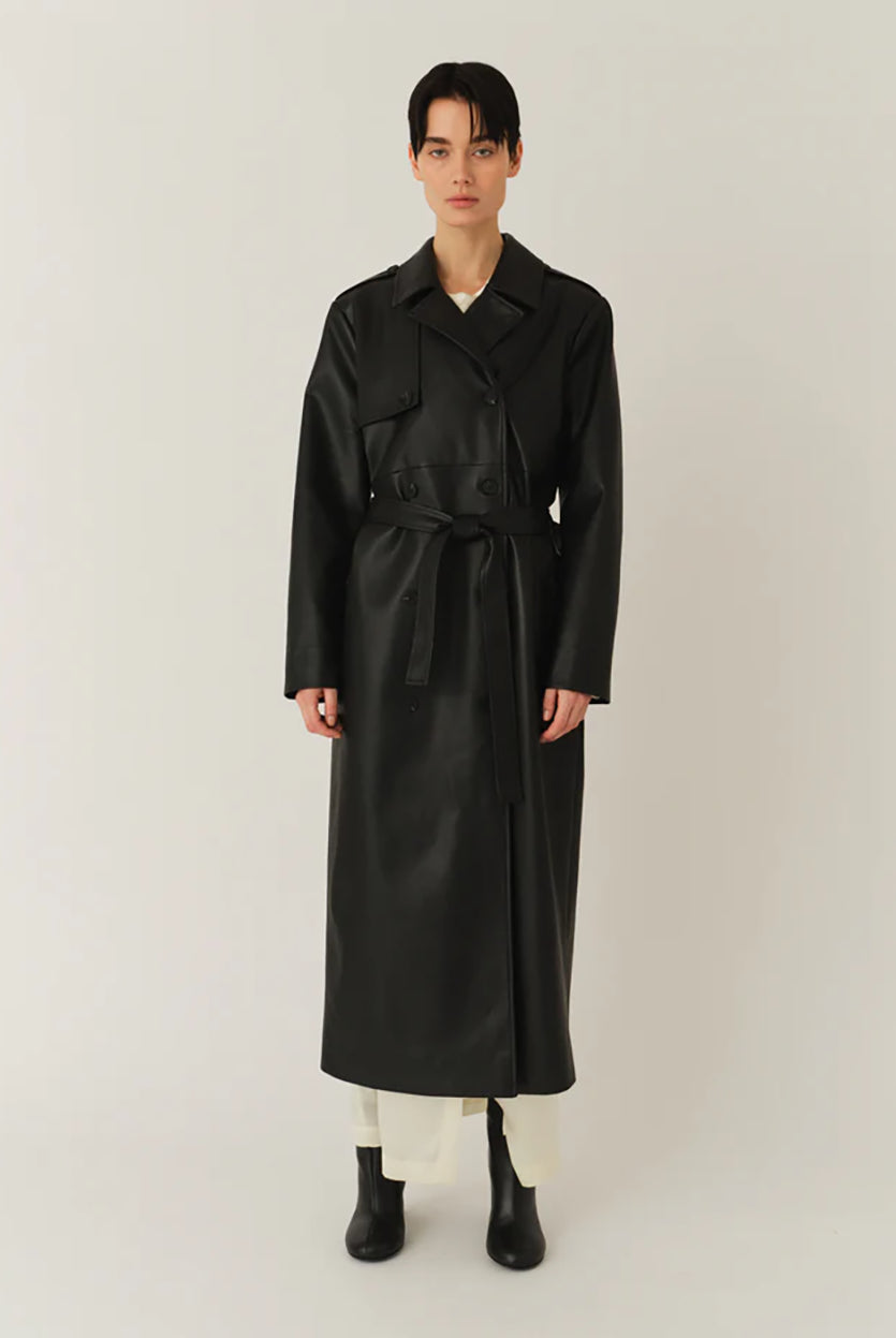 Długi, elegancki, dwurzędowy płaszcz Brooklyn Trench Black z klasycznymi detalami, wiązany w talii za pomocą wyciąganego, szerokiego paska. Posiada kołnierzyk, pagony na ramionach i luźne rękawy. Z tyłu u dołu ma rozcięcie. Płaszcz posiada dwie, boczne kieszenie. Jest zapinany na guziki. Wykończony w matowym, czarnym kolorze.
