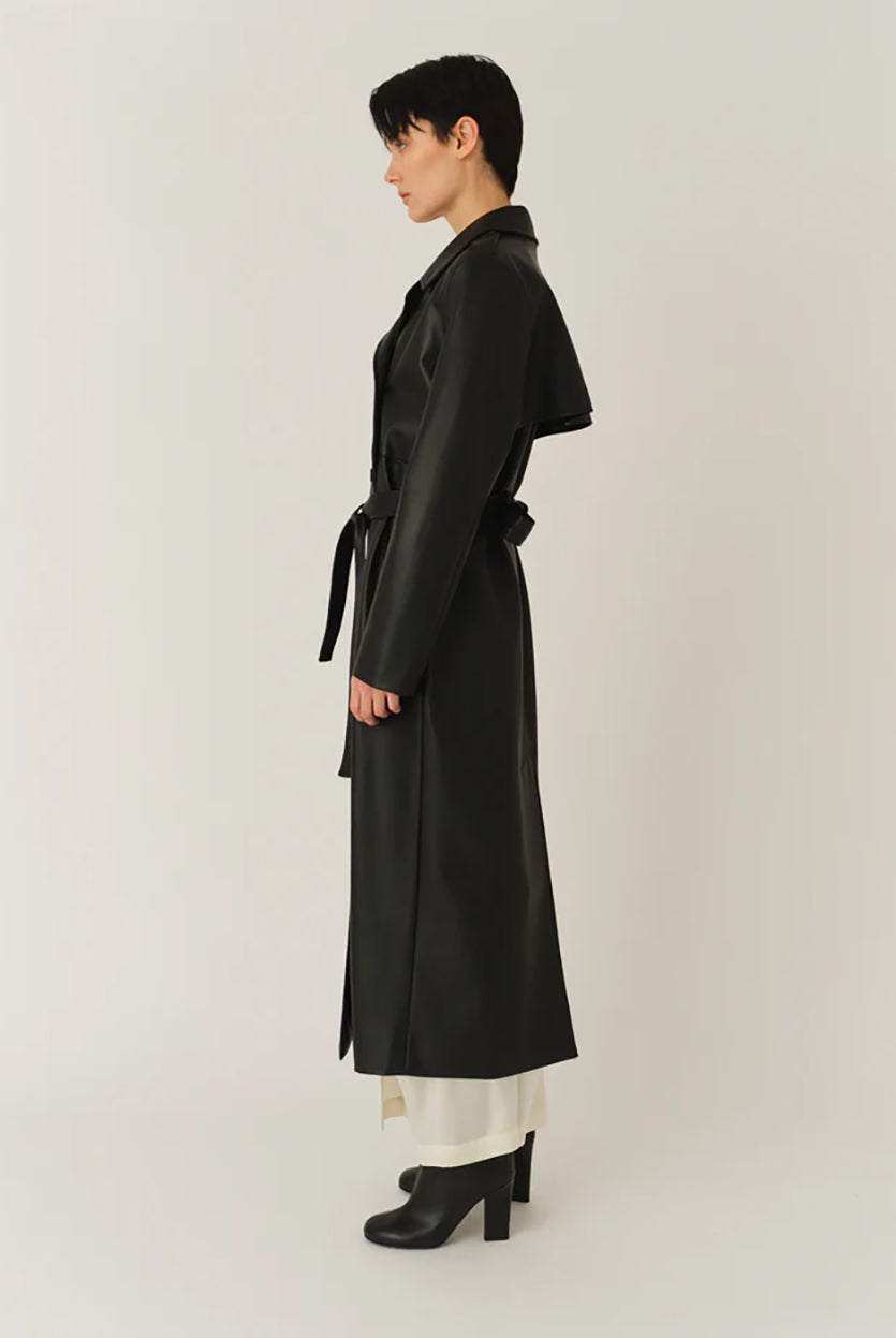 Długi, elegancki, dwurzędowy płaszcz Brooklyn Trench Black z klasycznymi detalami, wiązany w talii za pomocą wyciąganego, szerokiego paska. Posiada kołnierzyk, pagony na ramionach i luźne rękawy. Z tyłu u dołu ma rozcięcie. Płaszcz posiada dwie, boczne kieszenie. Jest zapinany na guziki. Wykończony w matowym, czarnym kolorze.