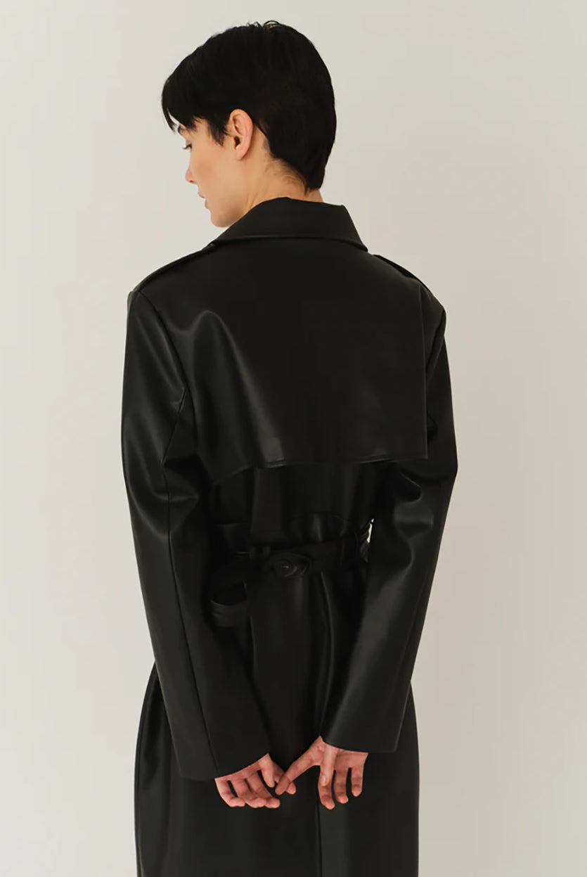 Długi, elegancki, dwurzędowy płaszcz Brooklyn Trench Black z klasycznymi detalami, wiązany w talii za pomocą wyciąganego, szerokiego paska. Posiada kołnierzyk, pagony na ramionach i luźne rękawy. Z tyłu u dołu ma rozcięcie. Płaszcz posiada dwie, boczne kieszenie. Jest zapinany na guziki. Wykończony w matowym, czarnym kolorze.