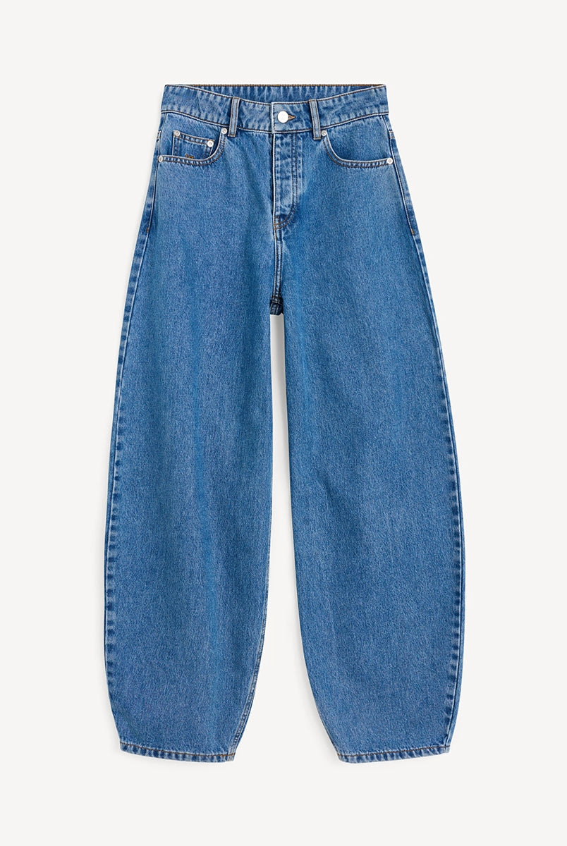 Niebieskie jeansy Dallas By Malne Birger o kroju barrel. Posiadają wysoki stan i szeroką, zaokrągloną nogawkę. Spodnie mają 5 kieszeni i szlufki na pasek. Zapinane na guzik i zamek błyskawiczny. Wykonane z bawełny organicznej. Idealne z przylegającym topem i japonkami oraz koszulą i balerinkami. -Wysoki stan -Luźny fason -Szeroka nogawka -Zamów spodnie w swoim normalnym rozmiarze