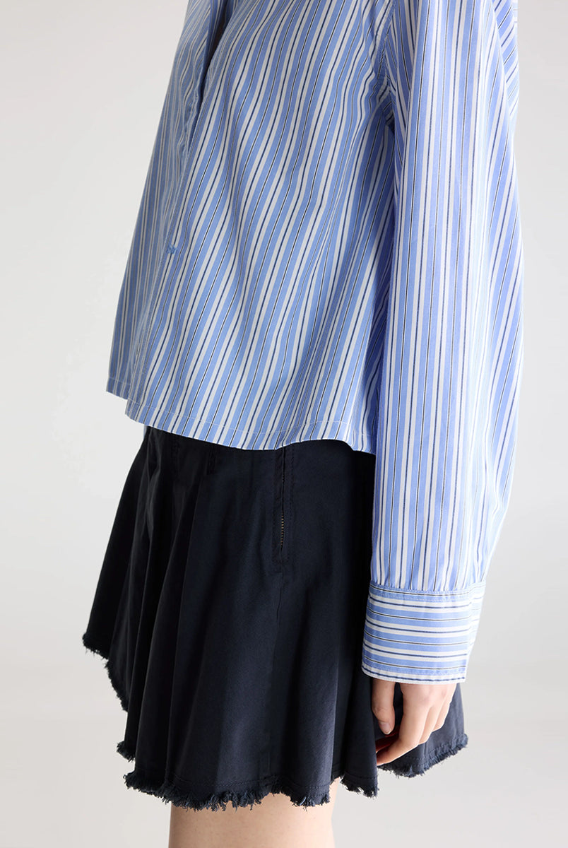 Luźna, krótka koszula Capri Stripe A marki BELLEROSE w niebieskie paski. Posiada klasyczny kołnierzyk oraz długie rękawy zakończone mankietami zapinanymi na guzik. Wykonana w 100% z bawełny. Z przodu przy guzikach ma wyhaftowane małe logo marki. Zapinana na guziki. Ma lekko skrócony fason.
-Zamów koszulę w swoim standardowym rozmiarze