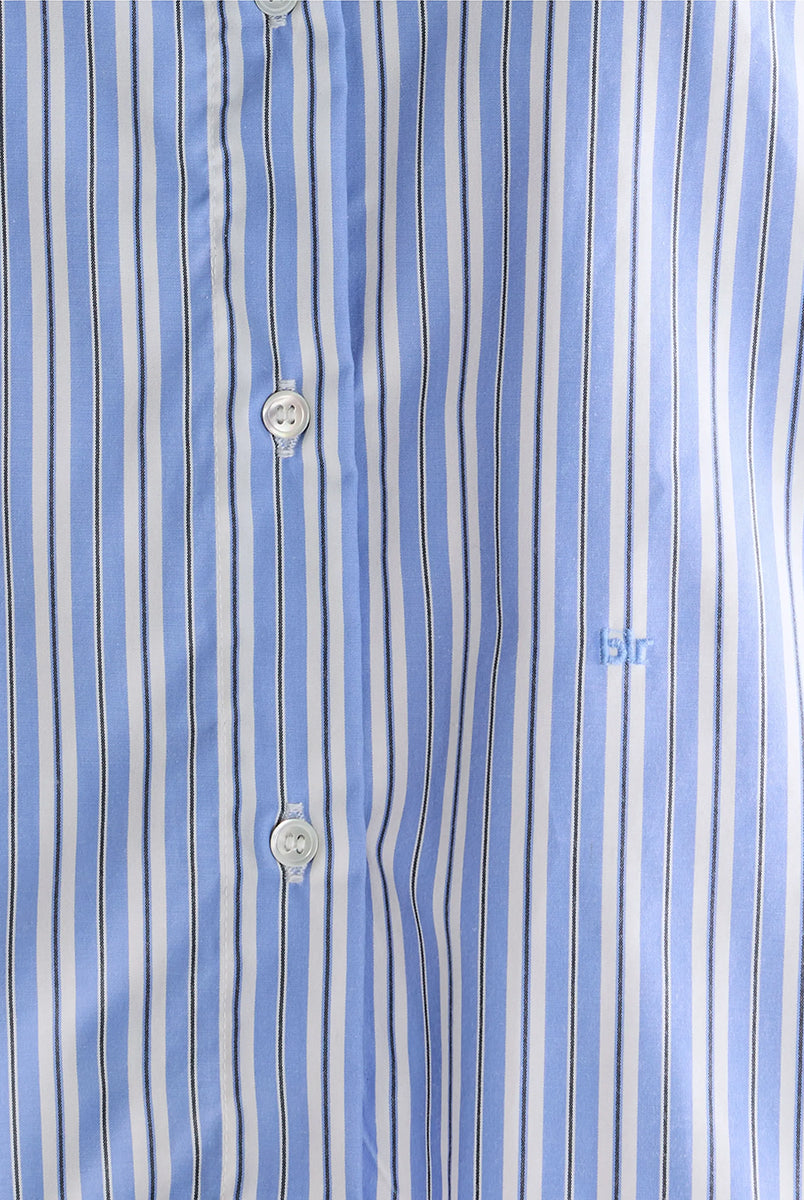 Luźna, krótka koszula Capri Stripe A marki BELLEROSE w niebieskie paski. Posiada klasyczny kołnierzyk oraz długie rękawy zakończone mankietami zapinanymi na guzik. Wykonana w 100% z bawełny. Z przodu przy guzikach ma wyhaftowane małe logo marki. Zapinana na guziki. Ma lekko skrócony fason.
-Zamów koszulę w swoim standardowym rozmiarze