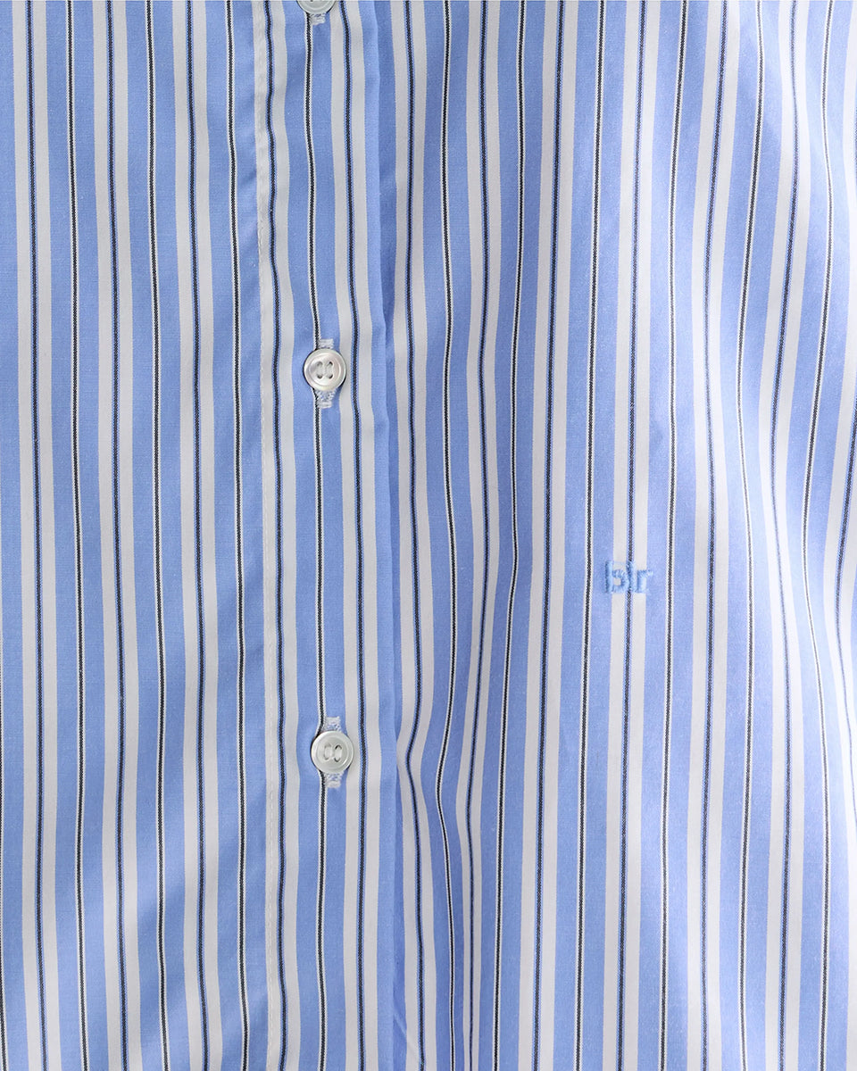 Luźna, krótka koszula Capri Stripe A marki BELLEROSE w niebieskie paski. Posiada klasyczny kołnierzyk oraz długie rękawy zakończone mankietami zapinanymi na guzik. Wykonana w 100% z bawełny. Z przodu przy guzikach ma wyhaftowane małe logo marki. Zapinana na guziki. Ma lekko skrócony fason.
-Zamów koszulę w swoim standardowym rozmiarze