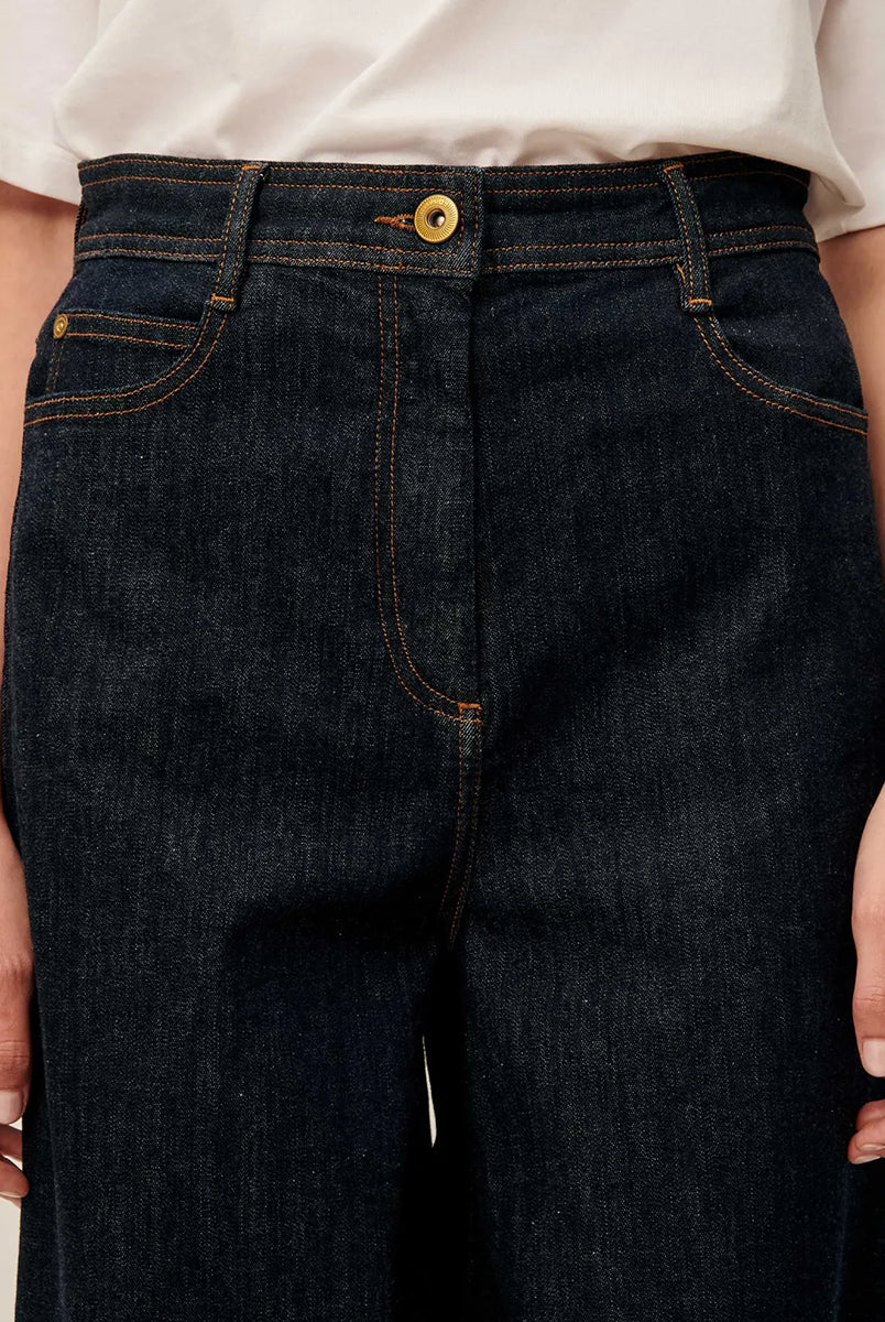 Ciemne Jeansy Captain Denim Rince z wysokim stanem i szerokimi nogawkami wykonane z denimu stonewash. Zapinane na guzik i kryty zamek błyskawiczny. Mają kieszenie z przodu oraz z tyłu i wytłoczoną, skórzaną naszywkę z logo marki.