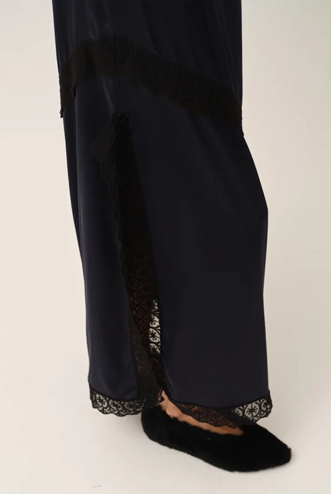 Elegancka, lejąca sukienka maxi na cienkich, regulowanych ramiączkach Cata Lace The Garment wykończona zmysłową koronką. Posiada prosty dekolt i głębokie wycięcie na plecach. Z przodu dekorowana asymetryczną koronką. Sukienka ma boczne rozcięcie oraz długość do kostek. Z tyłu delikatnie drapowana. Wykonana z jedwabnej, śliskiej tkaniny.
