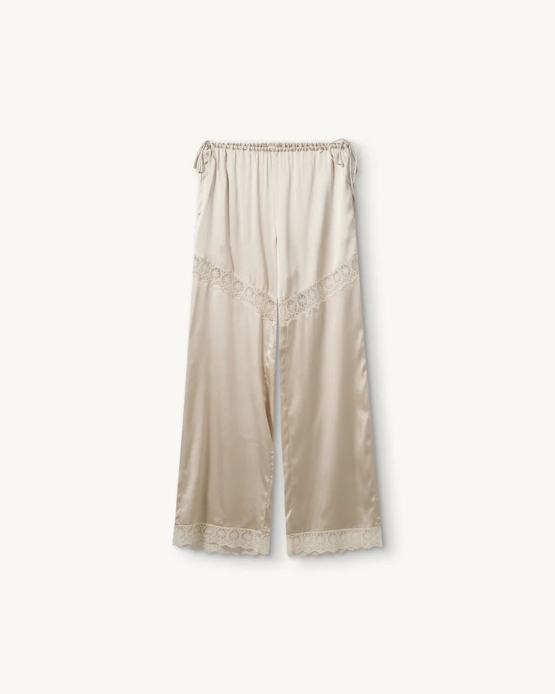 Lejące, jedwabne spodnie Cata Lace The Garment ze średnim stanem i prostą, luźną nogawką. Wiązane na bokach bioder. Wykończone zmysłową koronką.