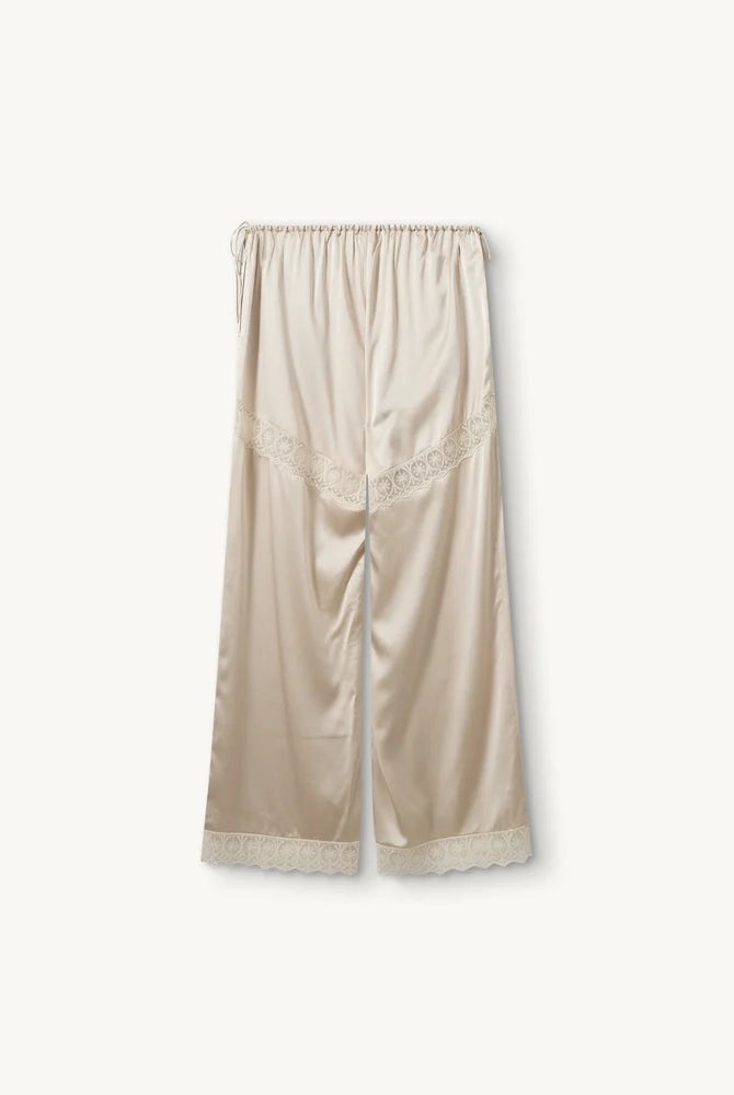 Lejące, jedwabne spodnie Cata Lace The Garment ze średnim stanem i prostą, luźną nogawką. Wiązane na bokach bioder. Wykończone zmysłową koronką.