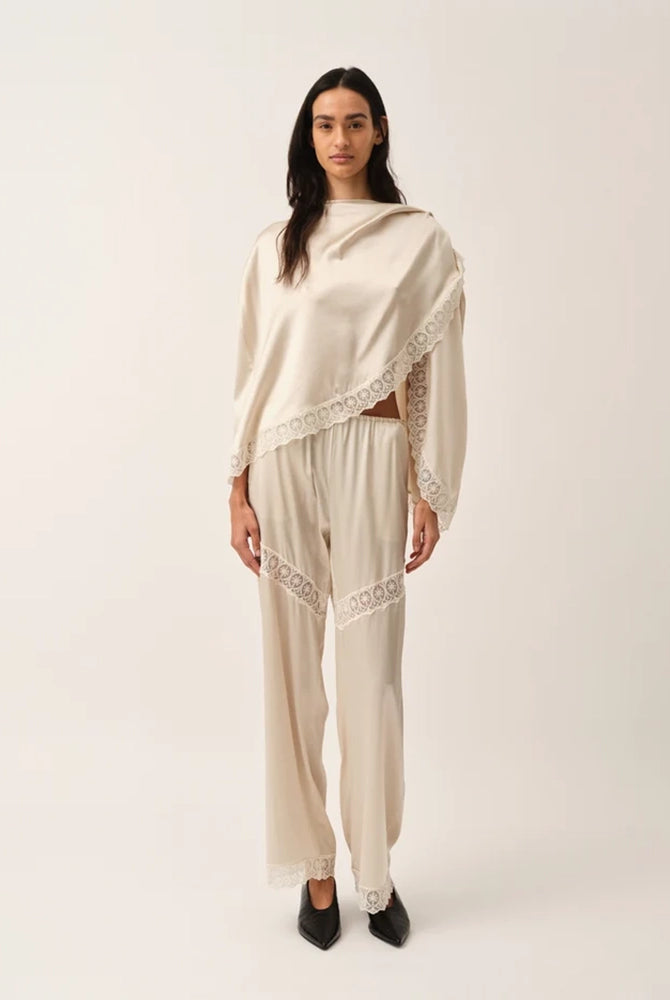Elegancka, jedwabna peleryna Cata The Garment o asymetrycznym fasonie. Zebrana na lewym ramieniu. Wykończona zmysłową koronką. Wykonana z lejącej, jedwabnej tkaniny.