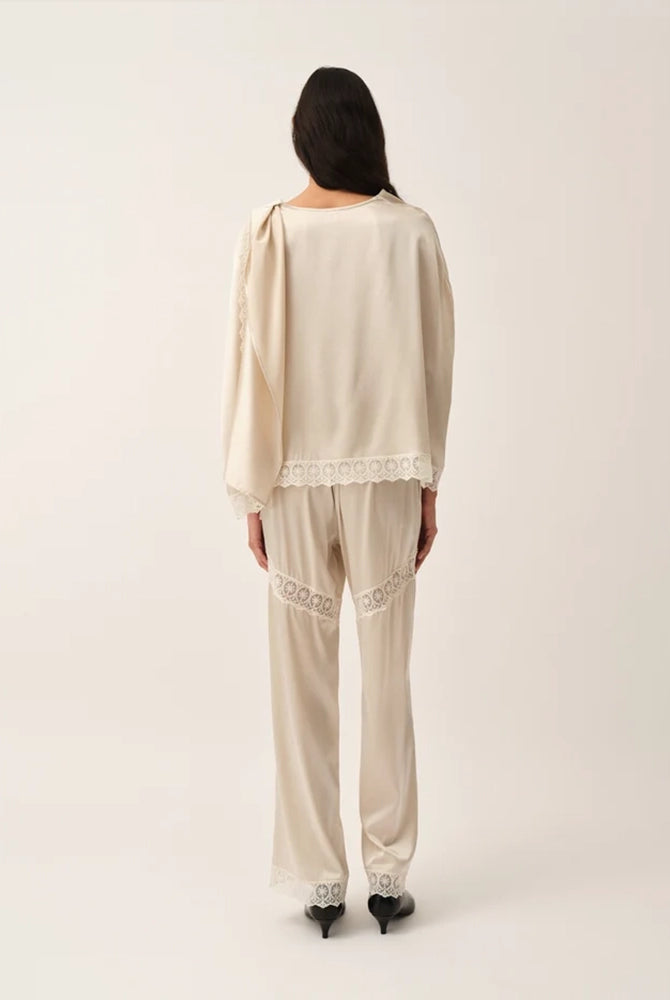 Lejące, jedwabne spodnie Cata Lace The Garment ze średnim stanem i prostą, luźną nogawką. Wiązane na bokach bioder. Wykończone zmysłową koronką.