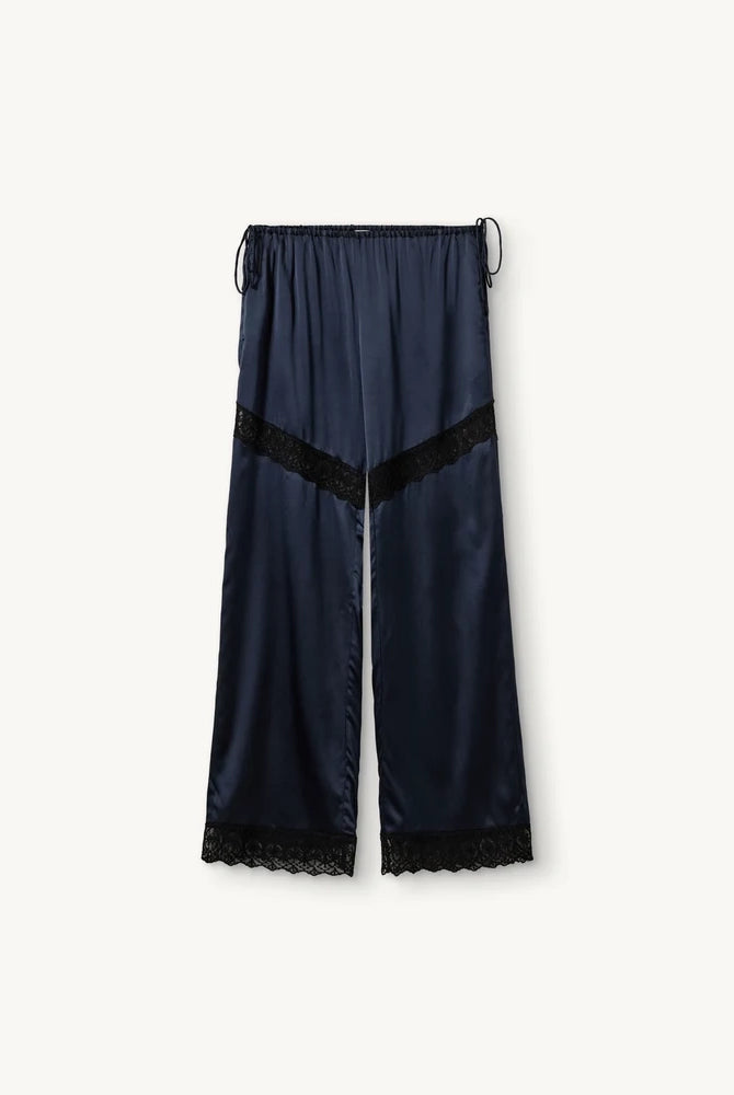 Lejące, jedwabne spodnie Cata Lace The Garment ze średnim stanem i prostą, luźną nogawką. Wiązane na bokach bioder. Wykończone zmysłową koronką. Idealne na co dzień i do wieczorowej, eleganckiej stylizacji.
