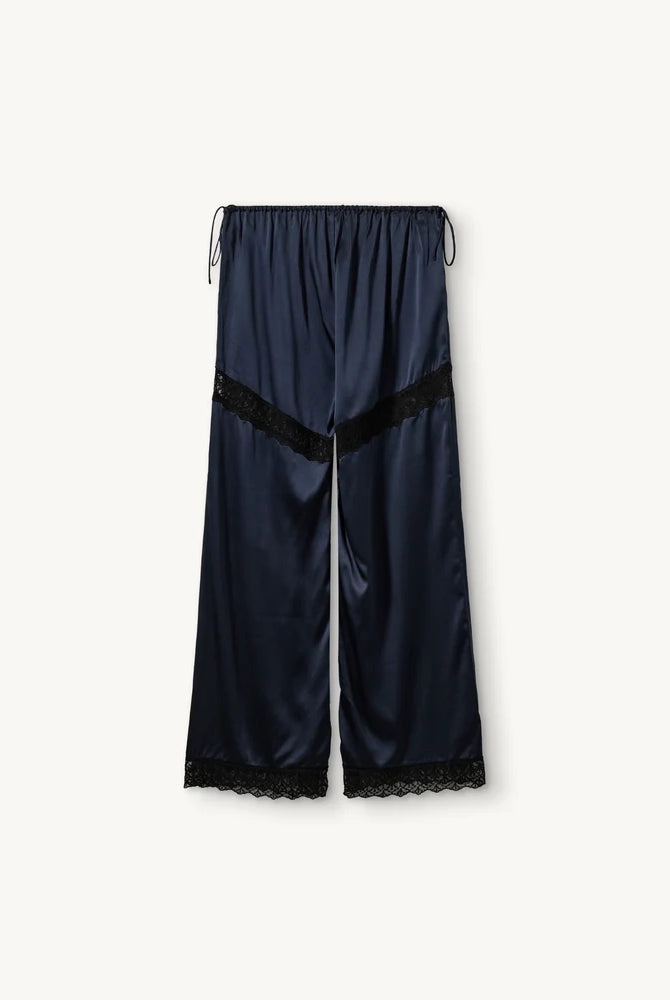 Lejące, jedwabne spodnie Cata Lace The Garment ze średnim stanem i prostą, luźną nogawką. Wiązane na bokach bioder. Wykończone zmysłową koronką. Idealne na co dzień i do wieczorowej, eleganckiej stylizacji.