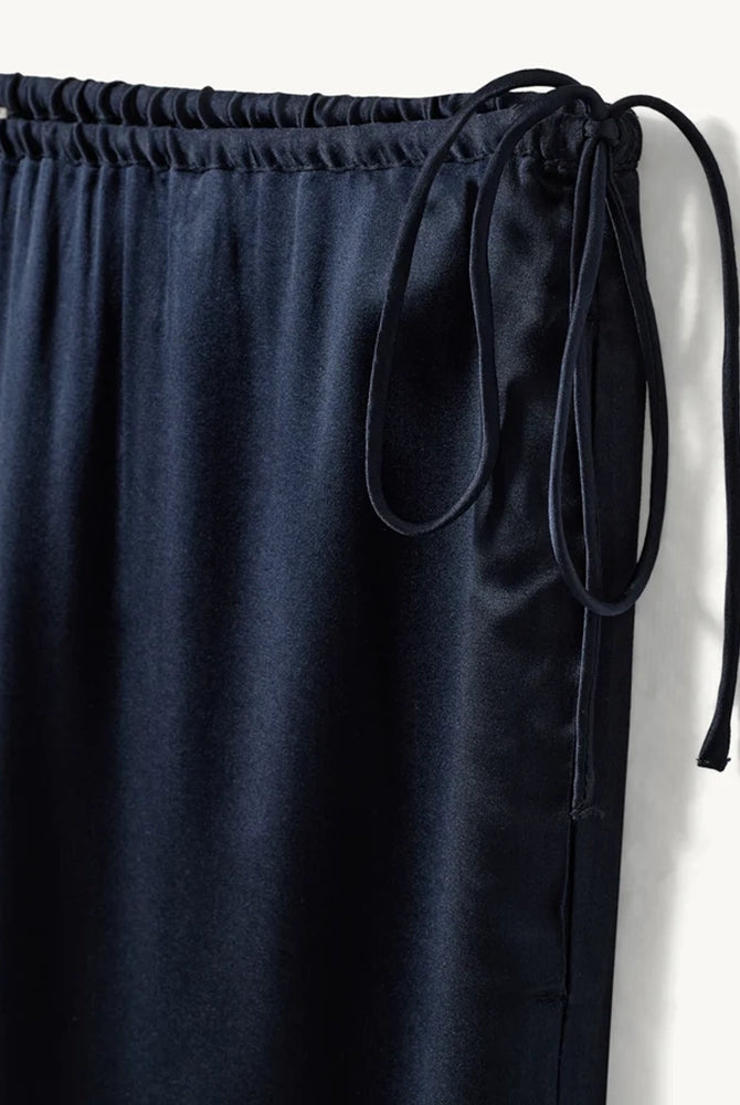 Lejące, jedwabne spodnie Cata Lace The Garment ze średnim stanem i prostą, luźną nogawką. Wiązane na bokach bioder. Wykończone zmysłową koronką. Idealne na co dzień i do wieczorowej, eleganckiej stylizacji.