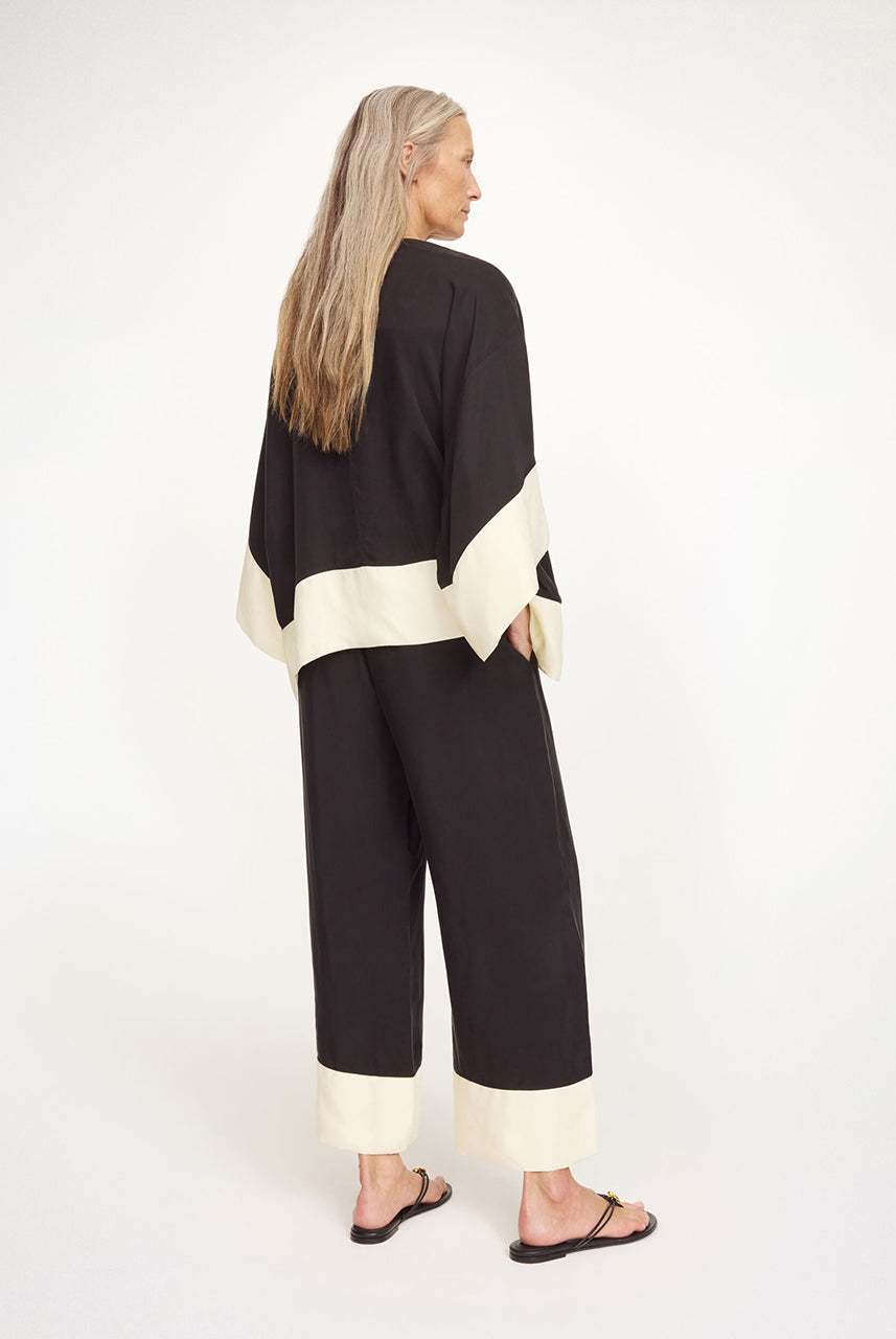 Elegancka, luźna bluzka Cicie Black White By Malene Birger o kwadratowym kroju, z głębokim dekoltem z zapięciem i szerokimi, krótkimi rękawami. Zapinana na haftkę i zatrzask. Wykonana z przewiewnej i gładkiej mieszanki cupro. Bluzka będzie idealną częścią stylizacji na eleganckie, wieczorne wyjścia.
-Luźny, kwadratowy krój
-Głęboki dekolt z zapięciem
-Zamów bluzkę w swoim standardowym rozmiarze