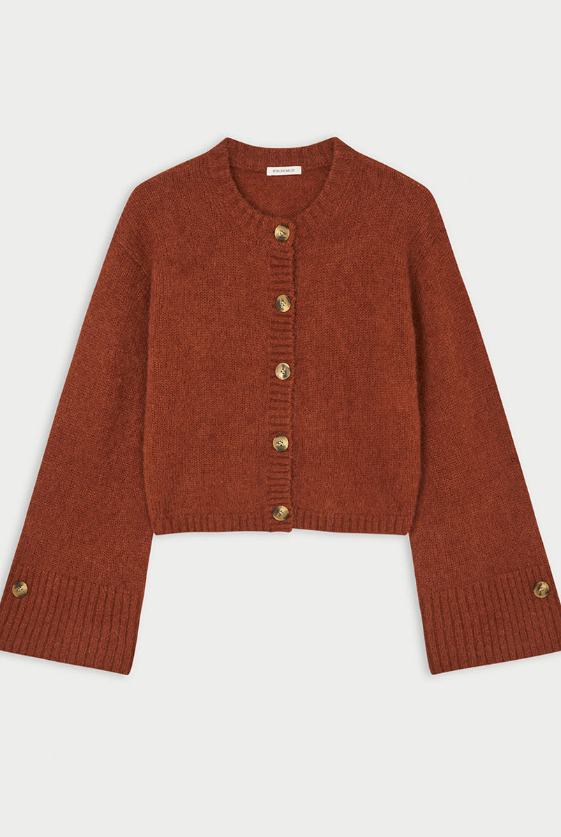 Krótki, swobodnie układający się sweter Cierrou Soft By Malene Birger Spiced Berry w rudym odcieniu. Ma okrągły dekolt i długie, lekko rozszerzane rękawy. Zapinany na rząd guzików. Dodatkowe, mniejsze guziki umieszczono również jako subtelny akcent na mankietach rękawów. Wykończony ściągaczami. Wykonany z ciepłej mieszanki wełny i moheru.
-Rozszerzane rękawy
-Dzianina z wełną i moherem
-Zamów sweter w swoim standardowym rozmiarze 