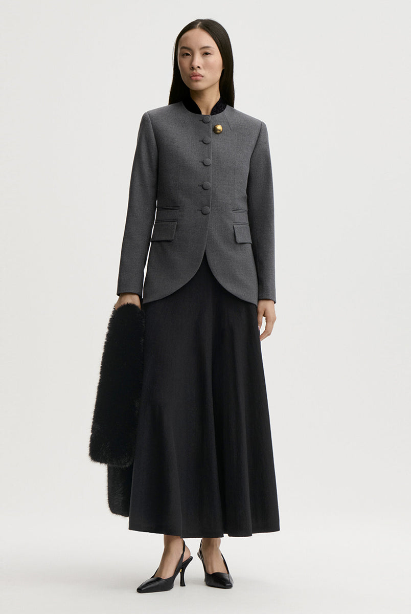 Dopasowana, jednorzędowa marynarka Claye By Malene Birger Dark Grey Melange w stylu vintage ze stójką. Zapinana na rząd drobnych, dyskretnych guzików. Fason charakteryzuje się mocno zaznaczoną, strukturalną linią ramion oraz zaokrąglonym dołem. U dołu po obu stronach umieszczono symetryczne kieszenie z klapkami, a dopasowane, proste rękawy dopełniają elegancki, formalny charakter. Posiada podszewkę i kieszeń wewnętrzną.
-Jednorzędowy fason
-Kontrastowa stójka
-Dopasowany krój