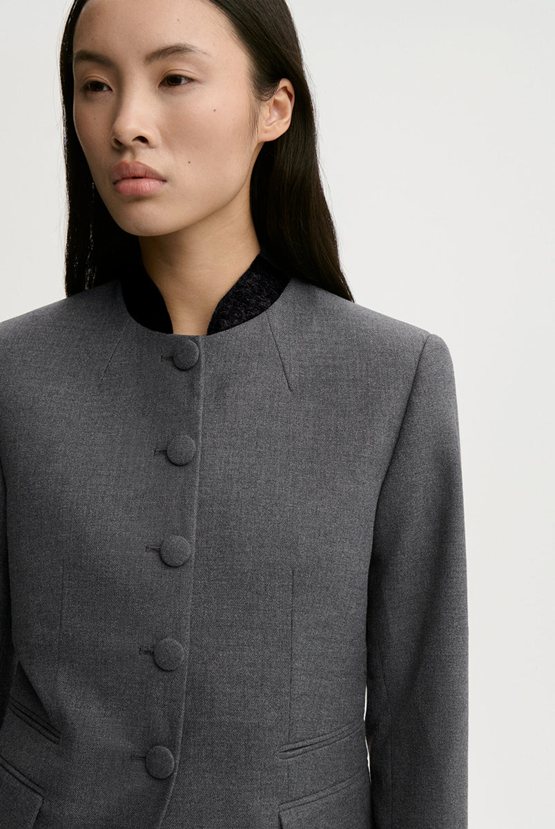 Dopasowana, jednorzędowa marynarka Claye By Malene Birger Dark Grey Melange w stylu vintage ze stójką. Zapinana na rząd drobnych, dyskretnych guzików. Fason charakteryzuje się mocno zaznaczoną, strukturalną linią ramion oraz zaokrąglonym dołem. U dołu po obu stronach umieszczono symetryczne kieszenie z klapkami, a dopasowane, proste rękawy dopełniają elegancki, formalny charakter. Posiada podszewkę i kieszeń wewnętrzną.
-Jednorzędowy fason
-Kontrastowa stójka
-Dopasowany krój