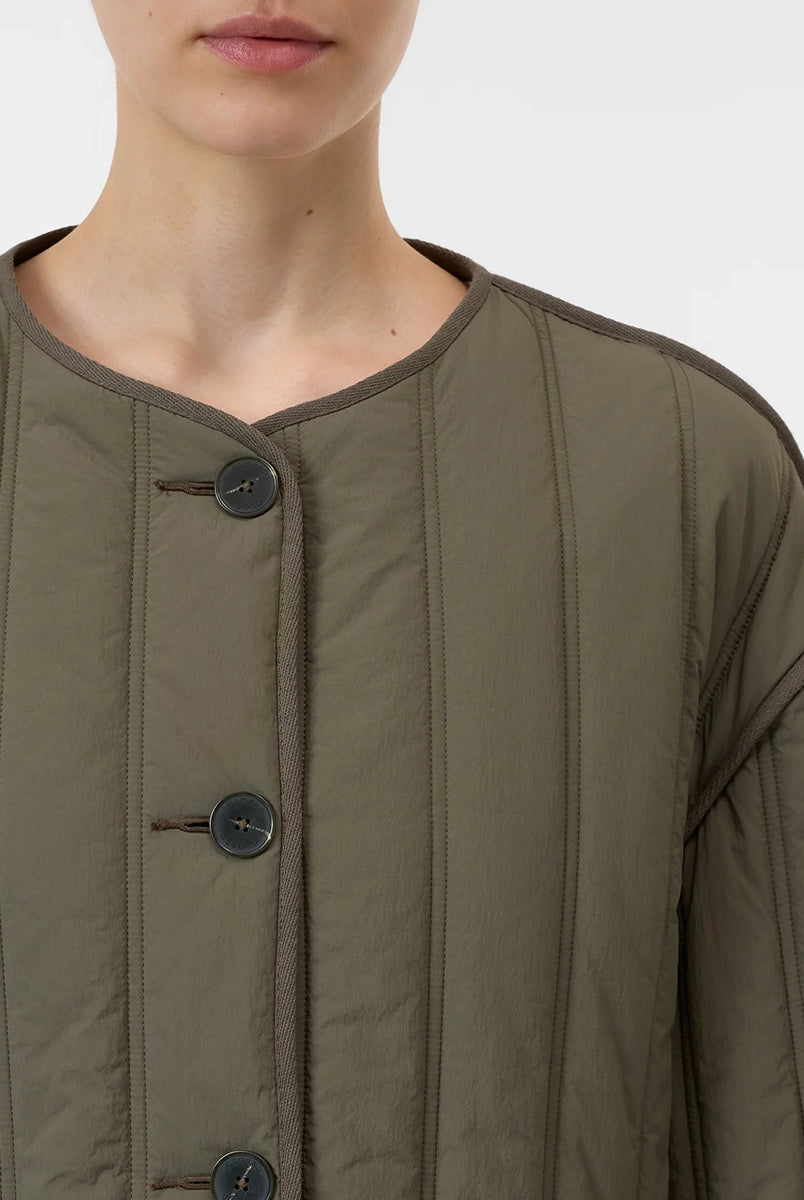 Krótka, pudełkowa, pikowana kurtka Quilted CLOSED z okrągłym dekoltem i opadającymi ramionami. Zapinana na guziki. Z boku posiada niewielkie rozcięcia oraz dwie, boczne kieszenie. Jest dłuższa z tyłu.
