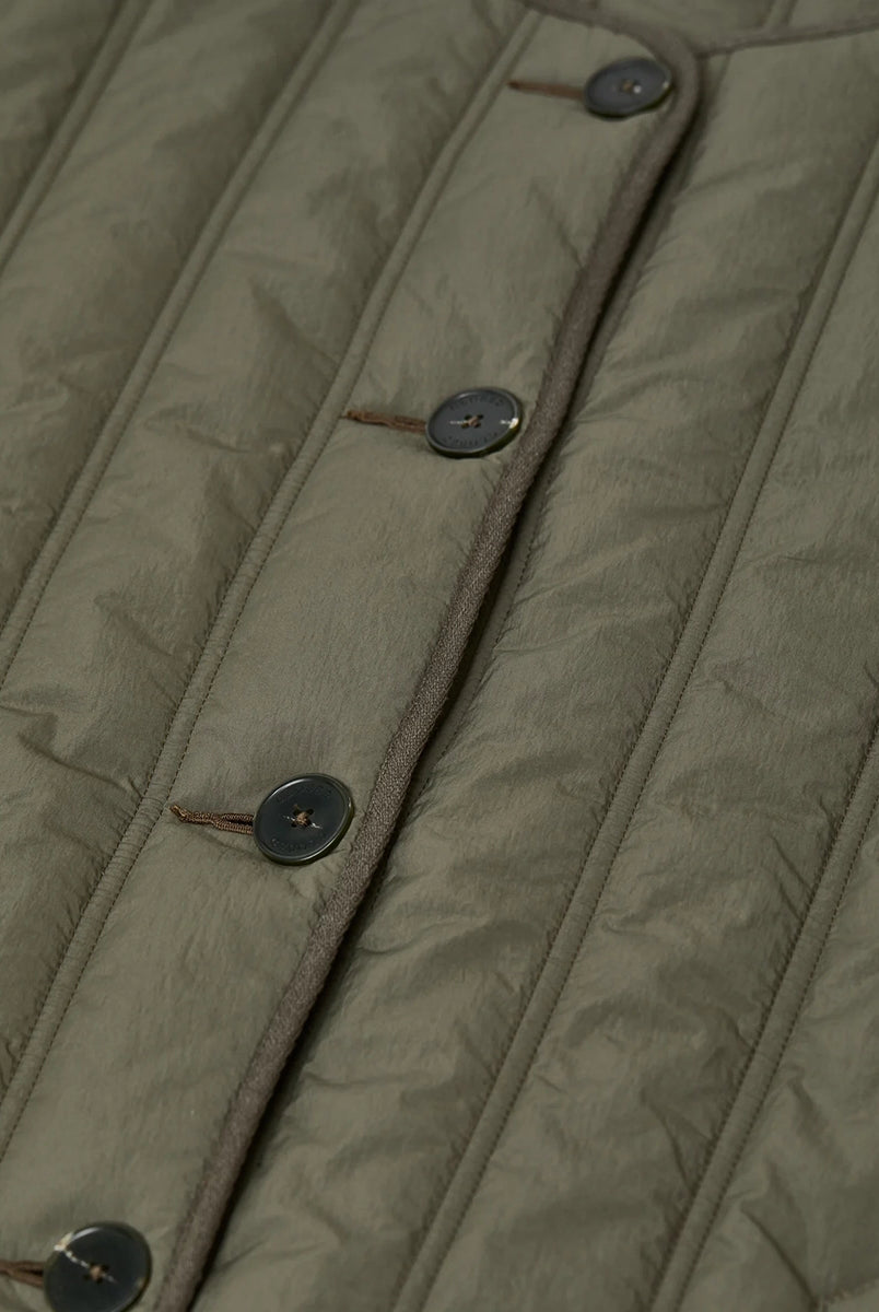 Krótka, pudełkowa, pikowana kurtka Quilted CLOSED z okrągłym dekoltem i opadającymi ramionami. Zapinana na guziki. Z boku posiada niewielkie rozcięcia oraz dwie, boczne kieszenie. Jest dłuższa z tyłu.